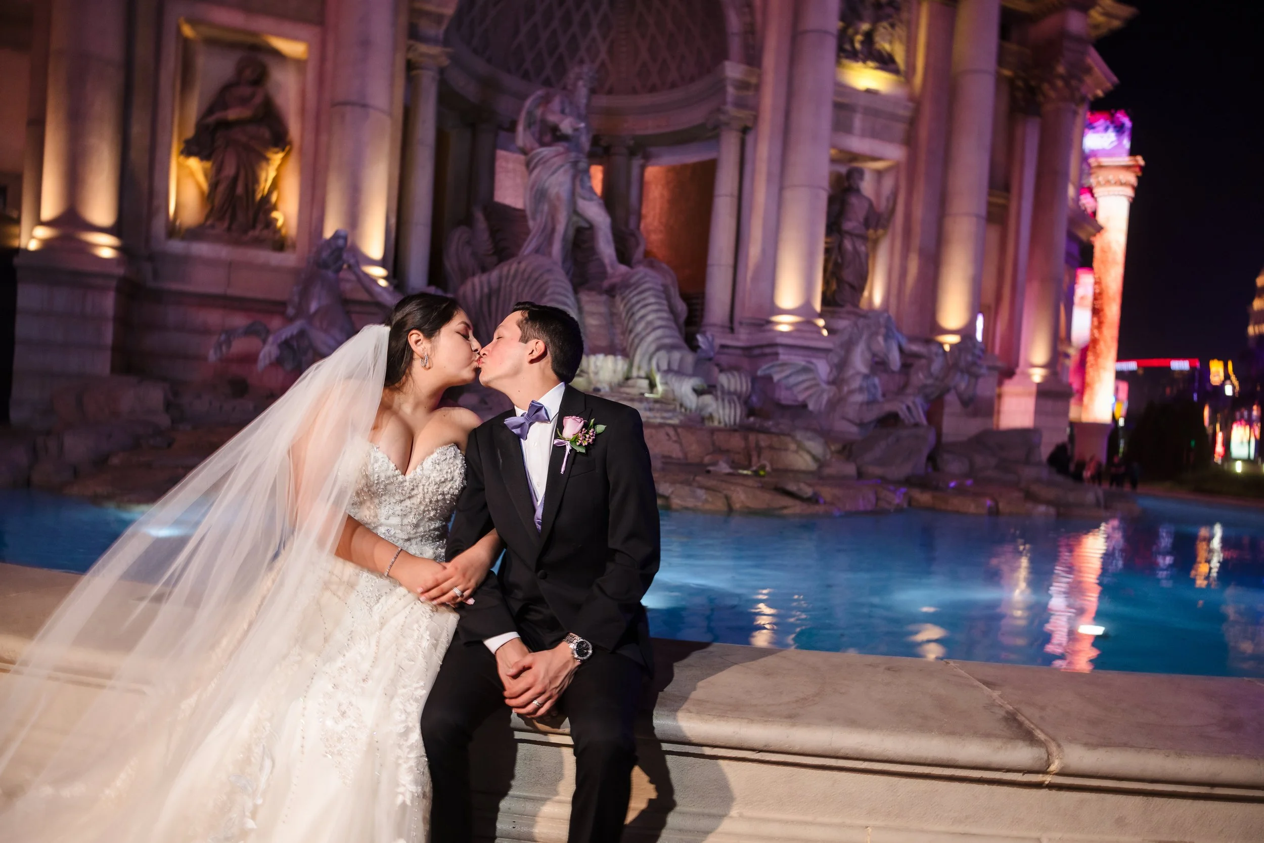 Couple kissing at night in front of an illuminated Las Vegas Strip fountain