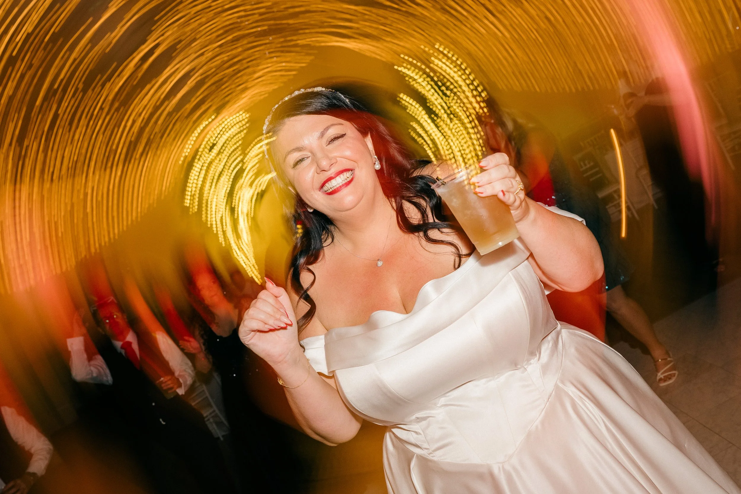 Bride laughing and dancing with guests during the reception