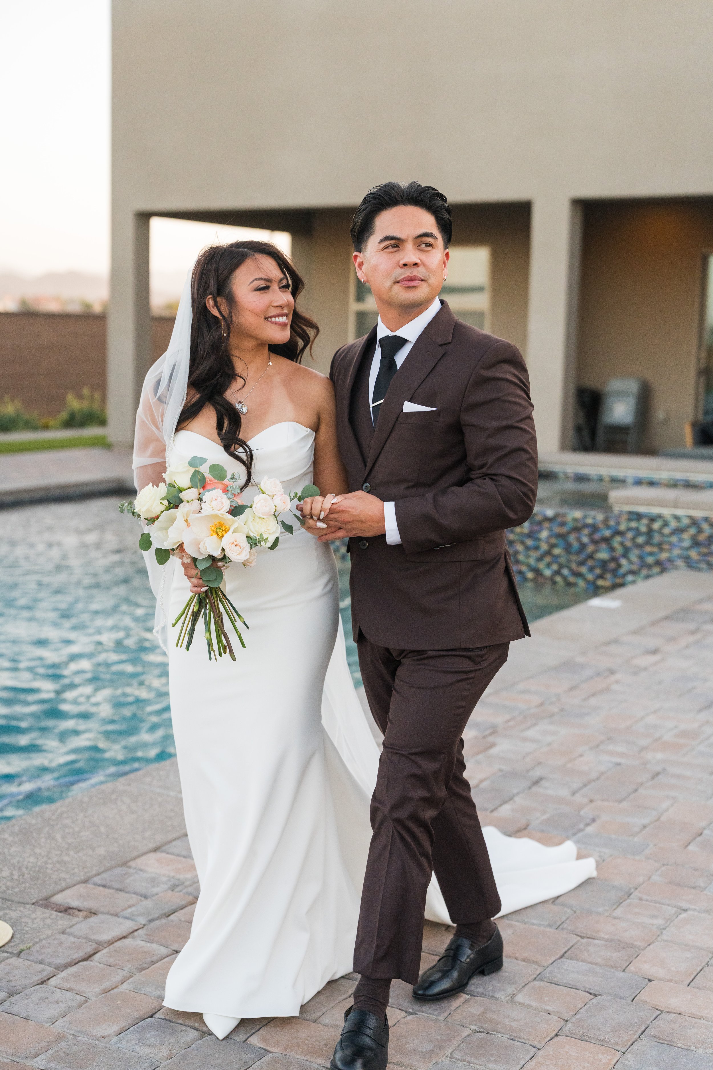 Bride and groom portrait beside a pool at golden hour