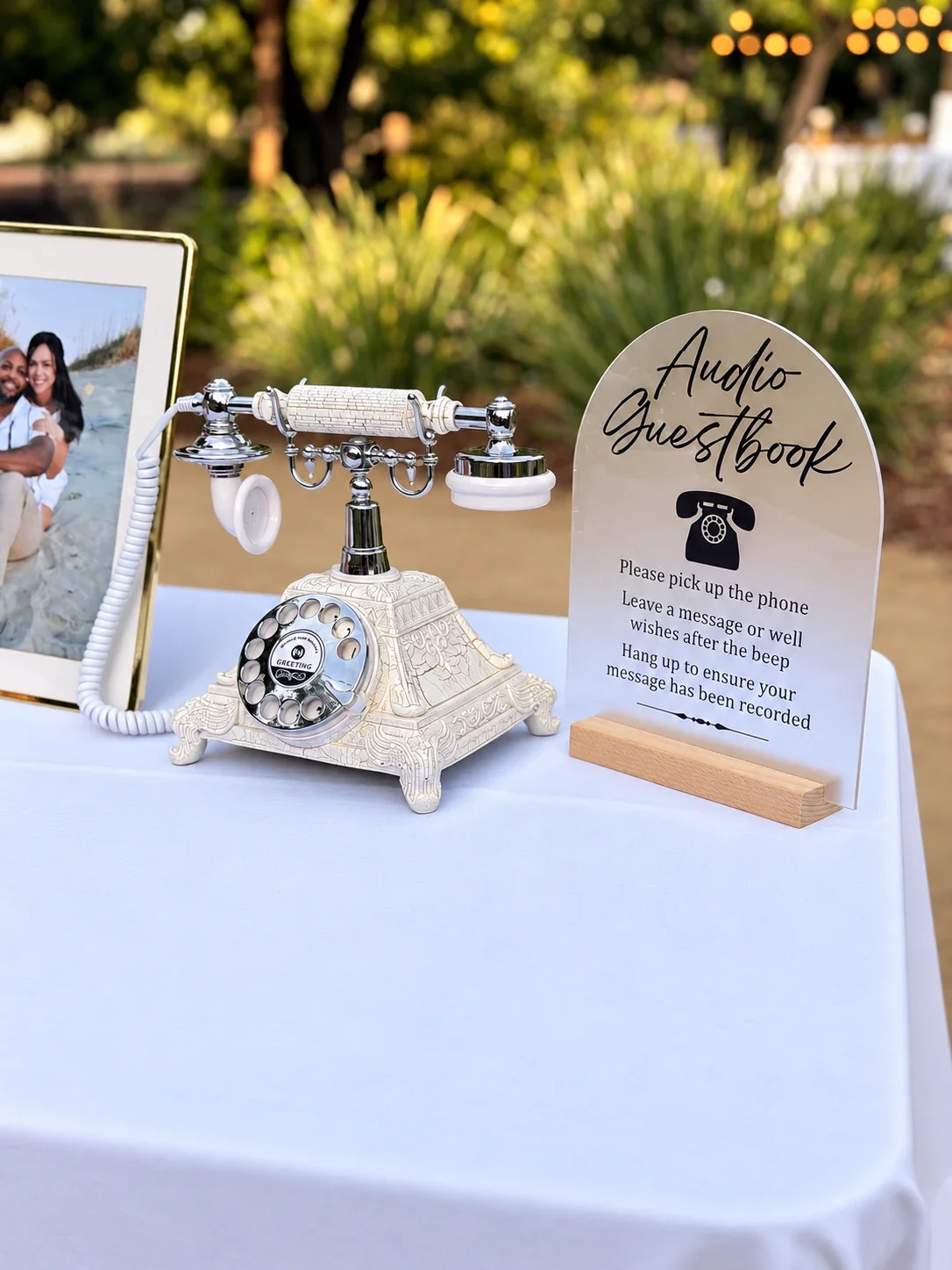 White vintage-style Audio Guest Book telephone with its instruction sign at an outdoor wedding reception