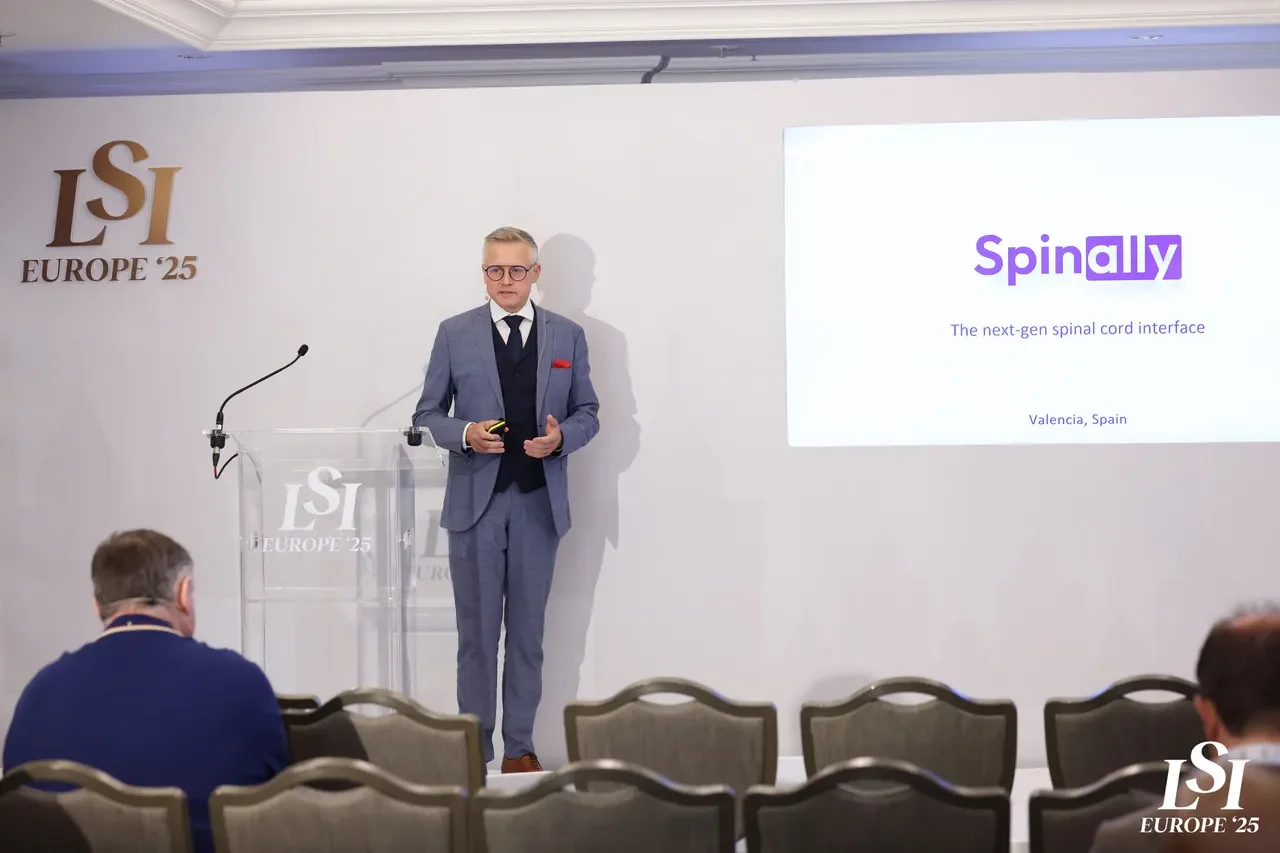 Pawel Soluch, CEO and co-founder of Spinally, speaking at the Life Science Intelligence (LSI) Europe 2025 event, standing beside a presentation screen