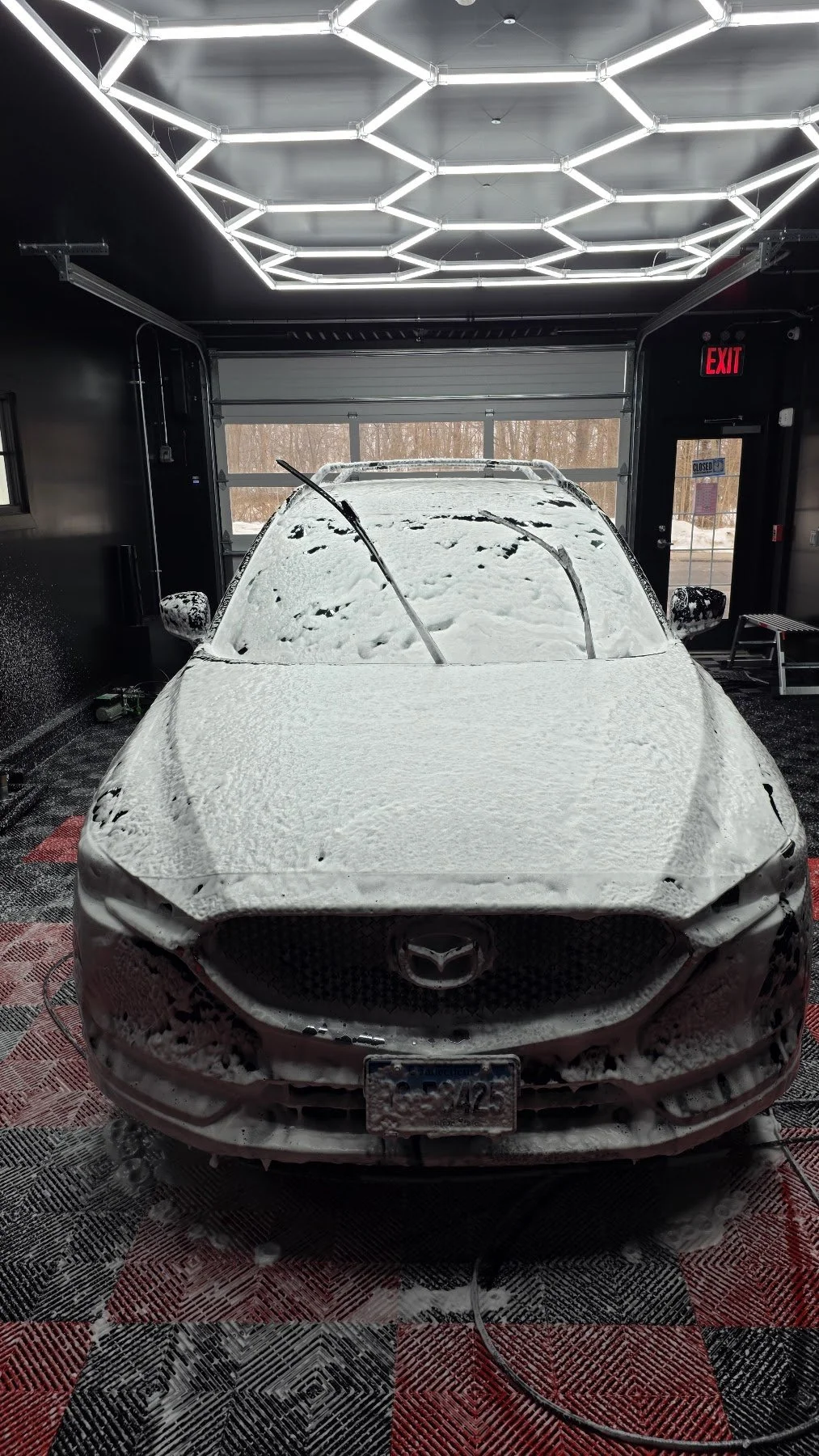 Foam-covered Mazda during washing in the shop
