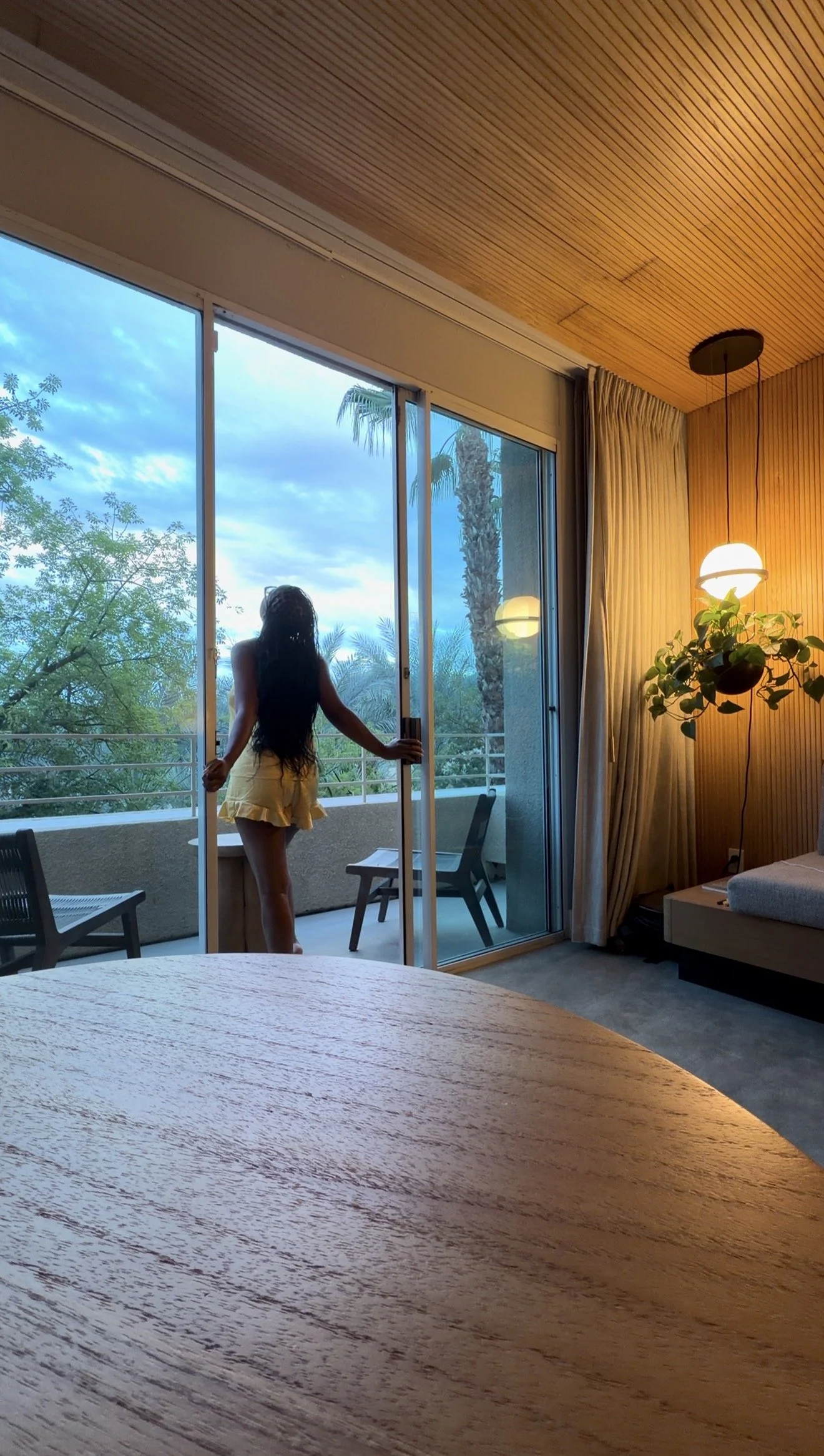 Briana pausing beside a window overlooking the outdoors