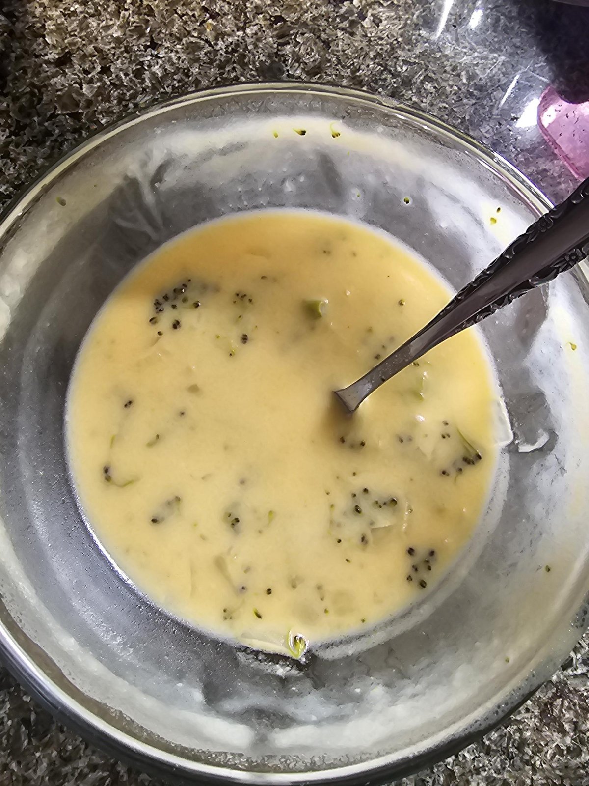 A bowl of homemade cream of broccoli soup with a spoon