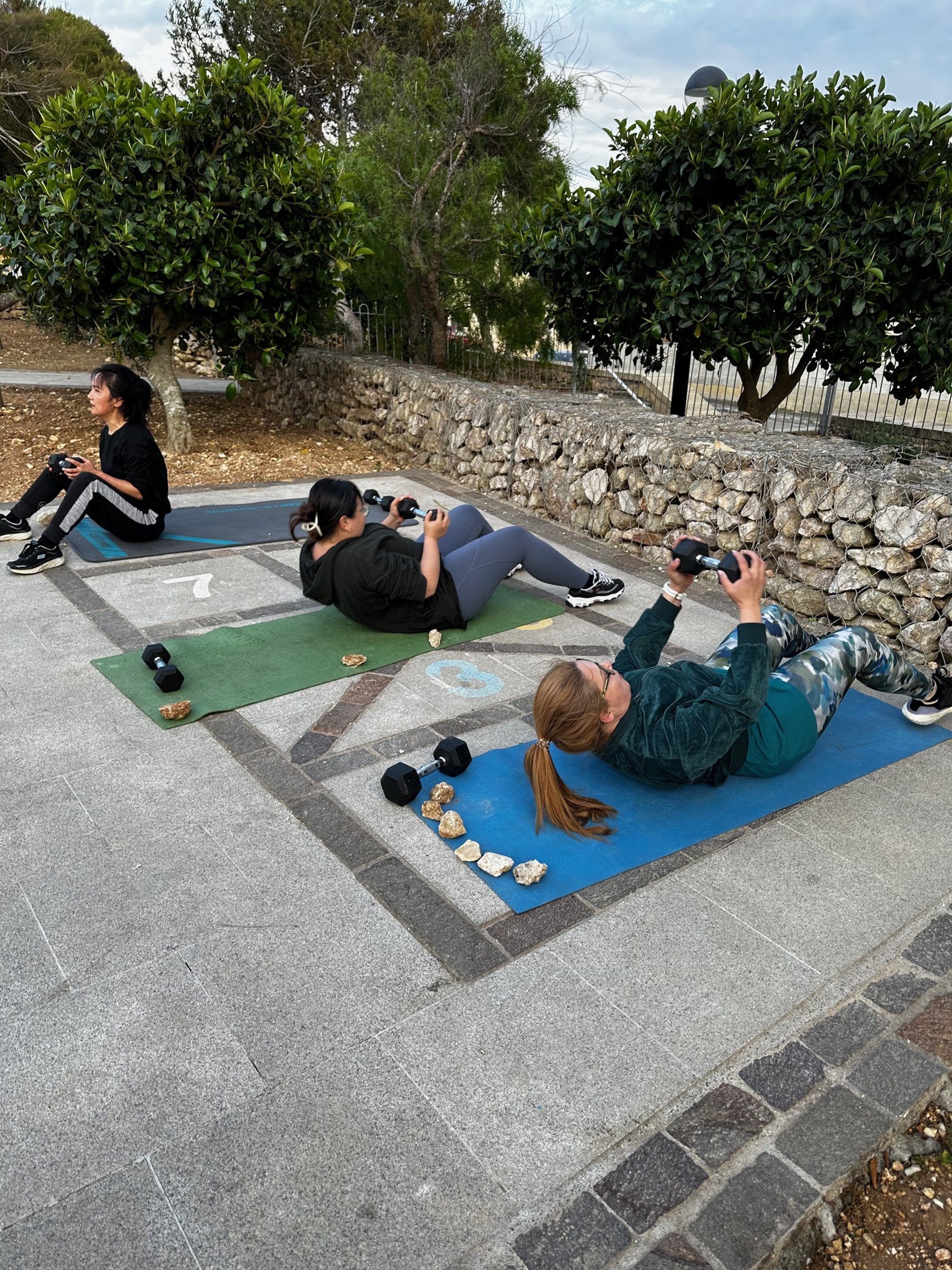 Clients doing situps with dumbells