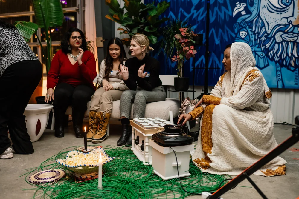 A coffee ceremony with guests seated around it