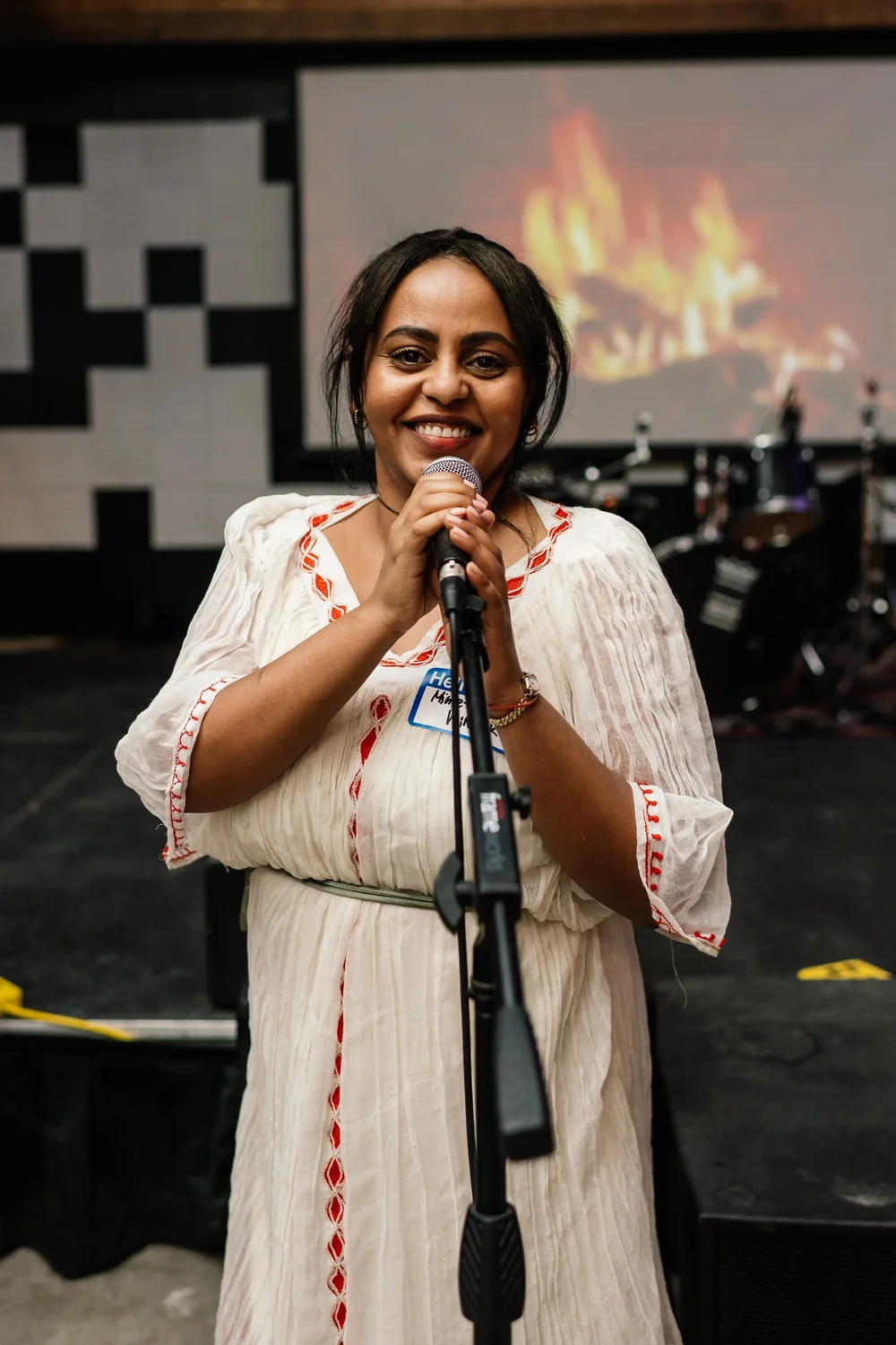 Mihret Haile speaking into a microphone and smiling