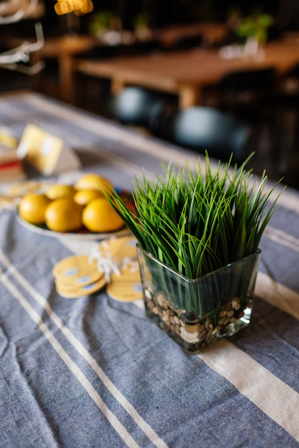 Lemons, greens and a striped cloth on a gathering table