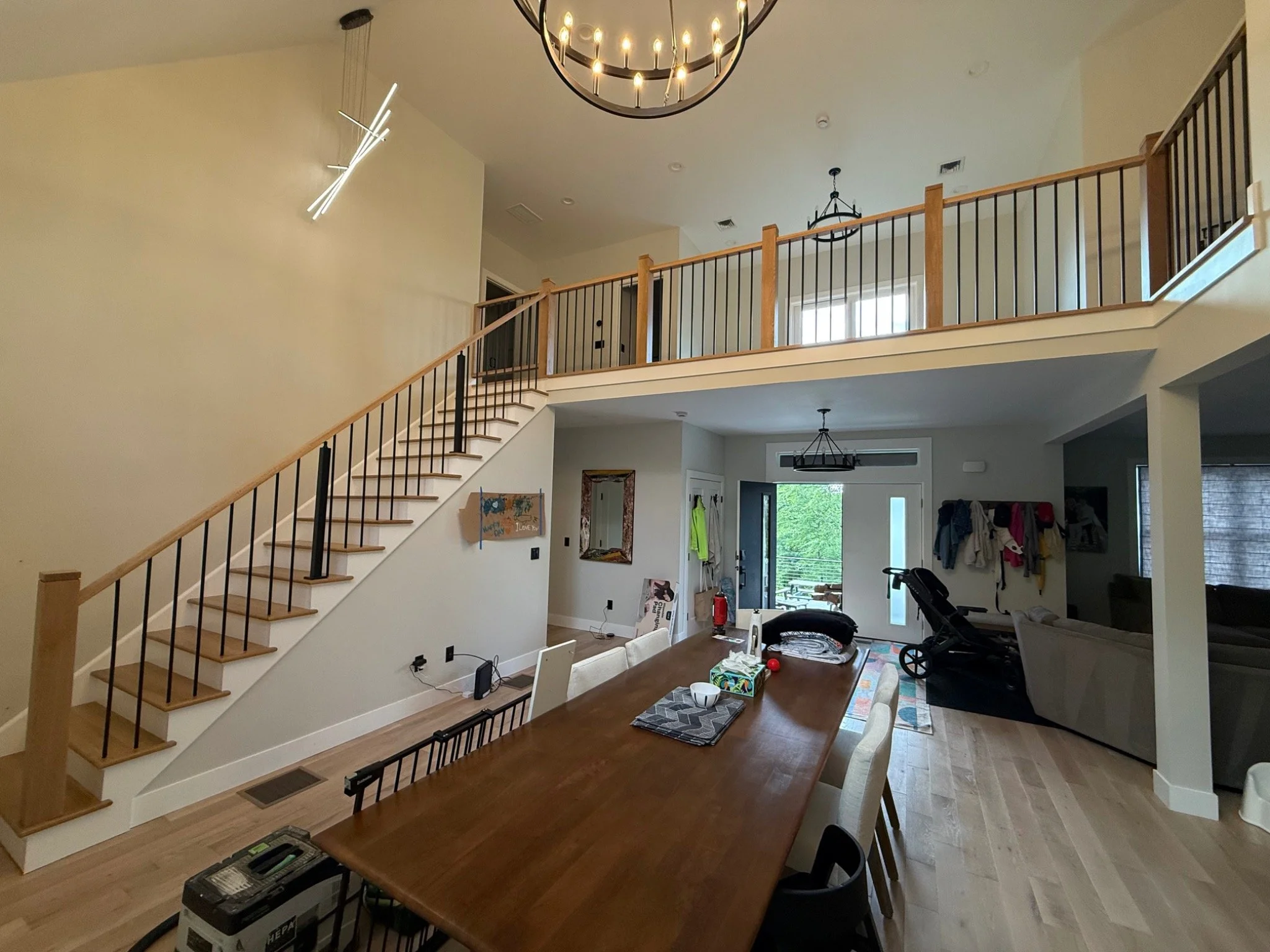 Wood staircase and long upper-level railing with black balusters