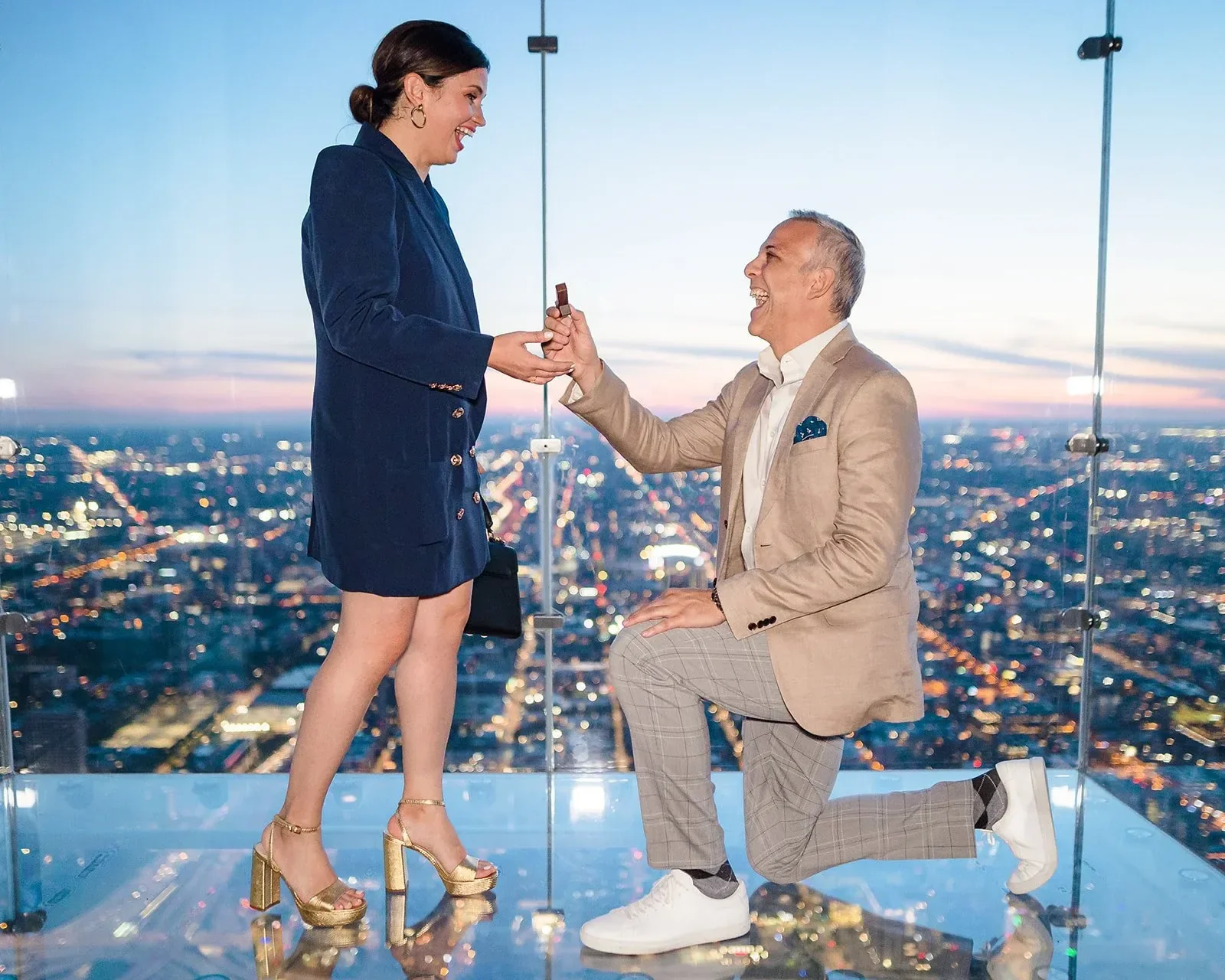 Couple on the Skydeck glass ledge at Willis Tower during a surprise proposal — Chicago proposal photography
