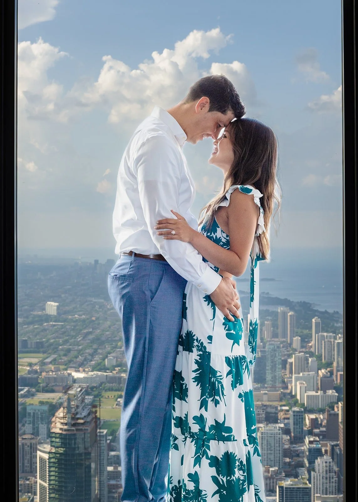 Couple embracing at Willis Tower 99th floor with panoramic Chicago skyline views — proposal photography by The Proposal Studios