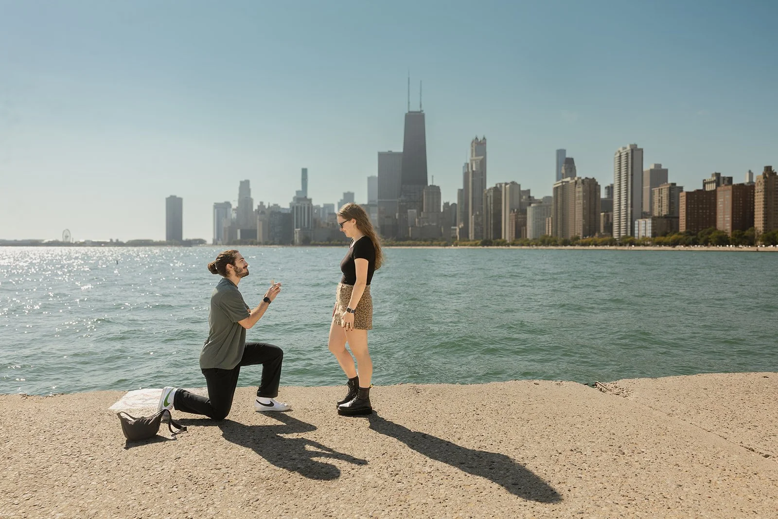 Surprise proposal on the sand at North Avenue Beach with skyline backdrop — Chicago proposal photographer