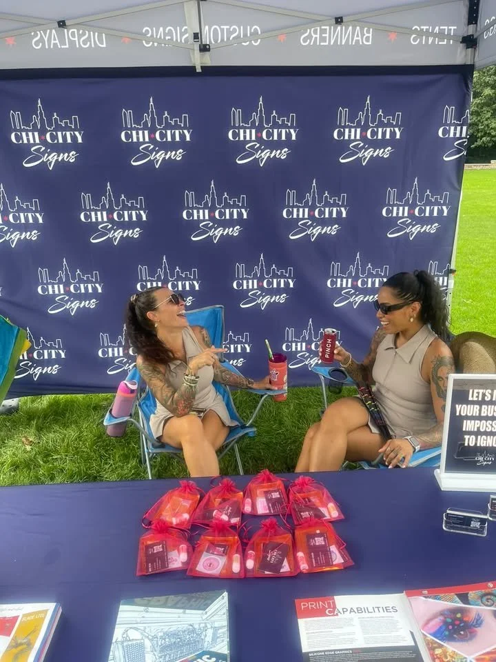 Chi City Signs branded tent and backdrop at an outdoor event