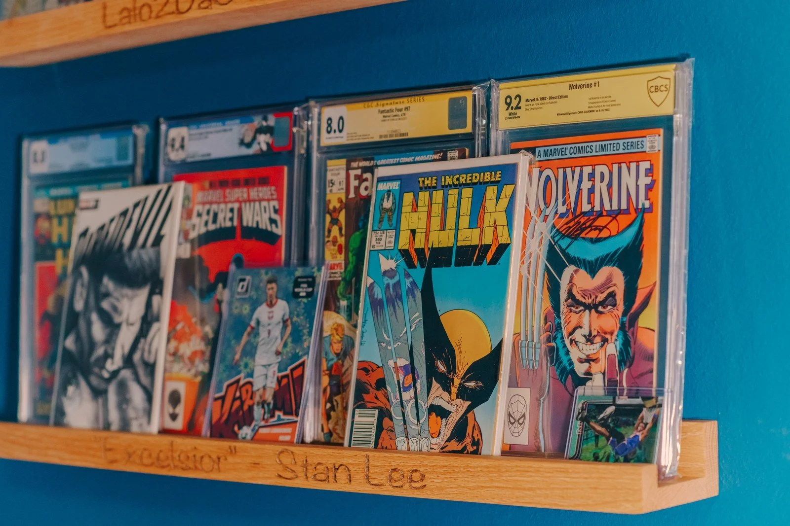 Graded and signed comic books displayed on a studio shelf