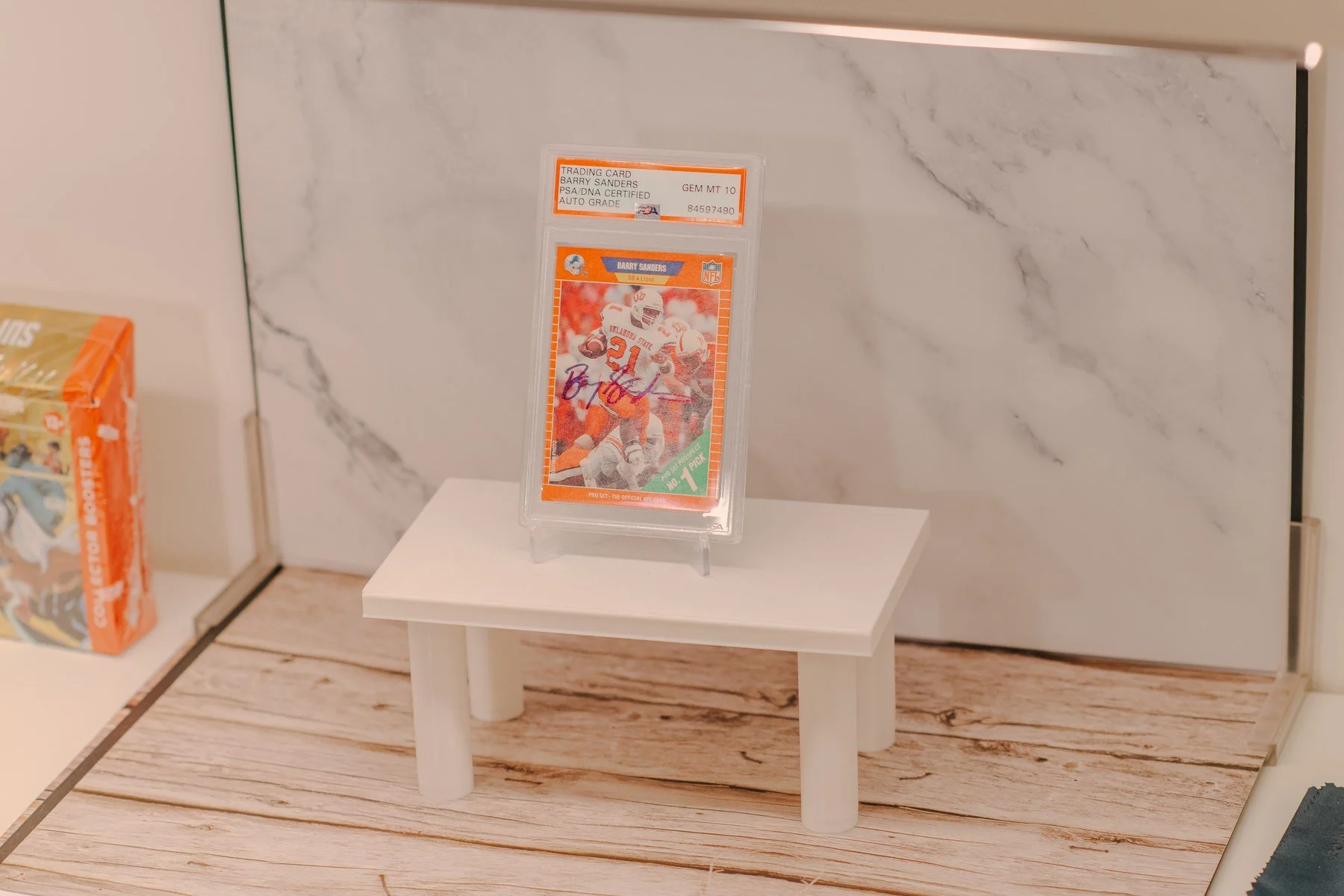 Autographed Barry Sanders card displayed on the Next Level Collectibles product photography stage