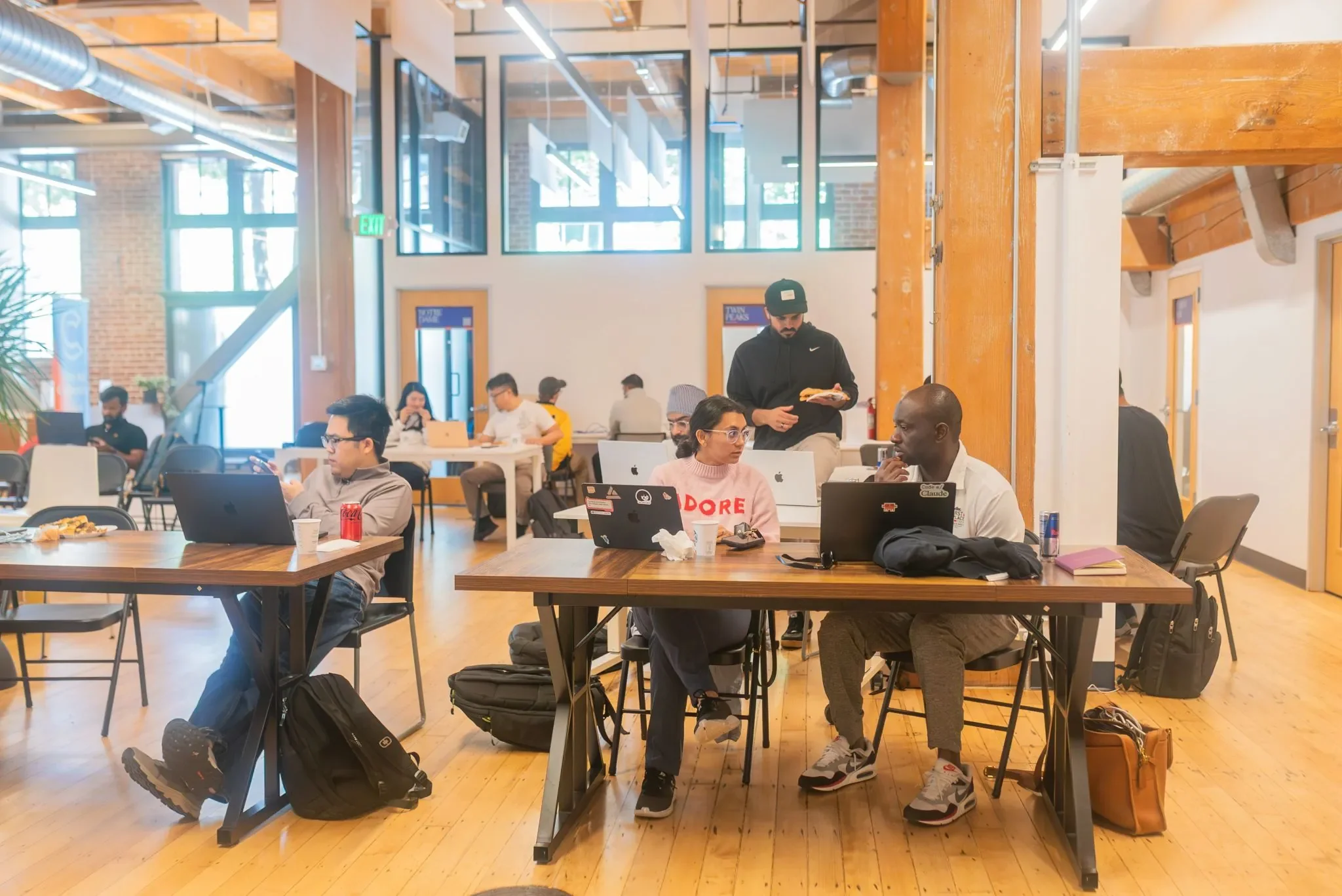 Hackathon teams collaborating with laptops