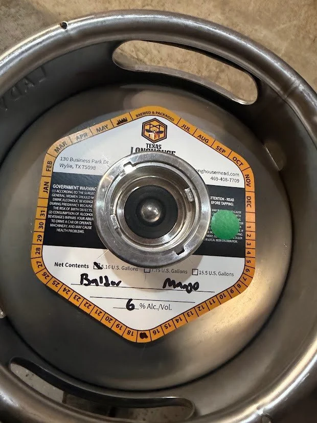 The original Texas Longhouse keg label handwritten Baldur, Mango, and 6% alcohol by volume.