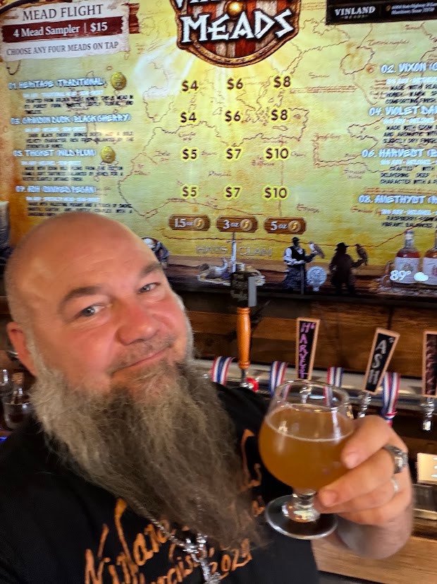 Clyde holding a glass of Apple Cider at the Vinland Meads tap bar