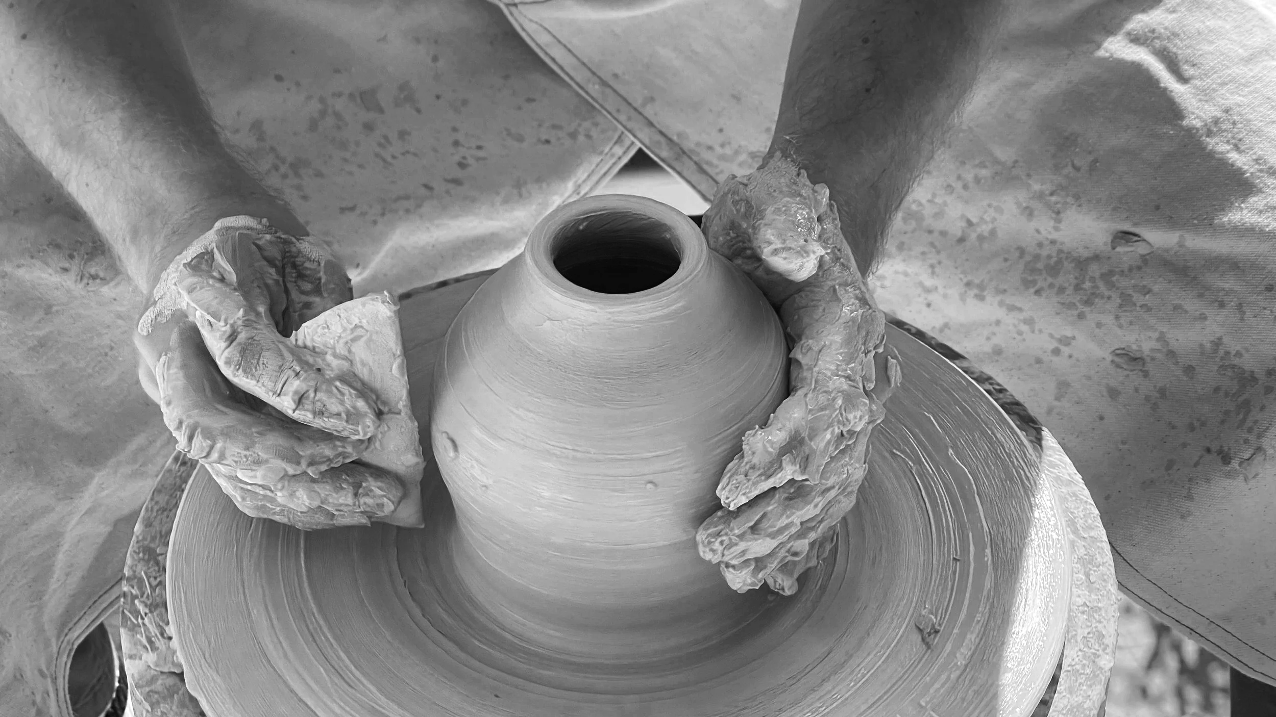 Potter working on a wheel in a ceramic studio