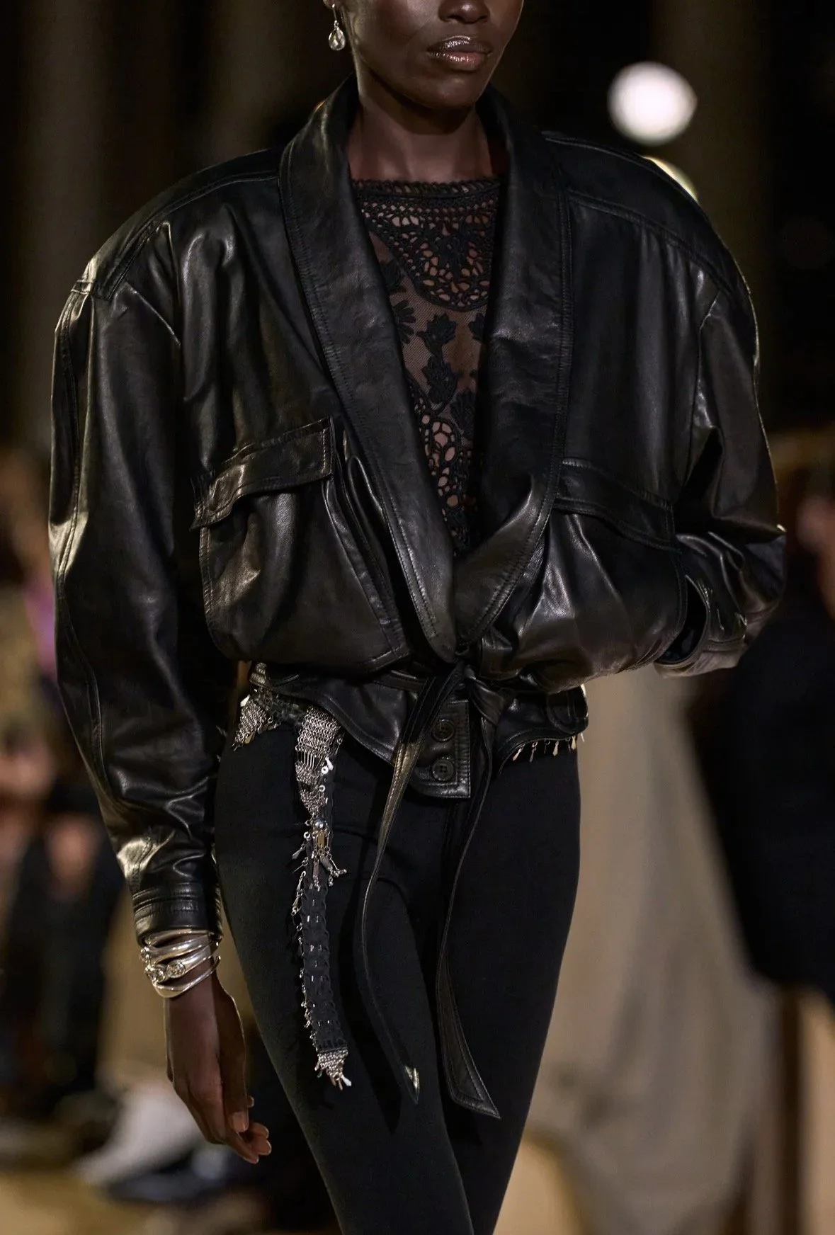A softly tied black jacket against intricate lace.