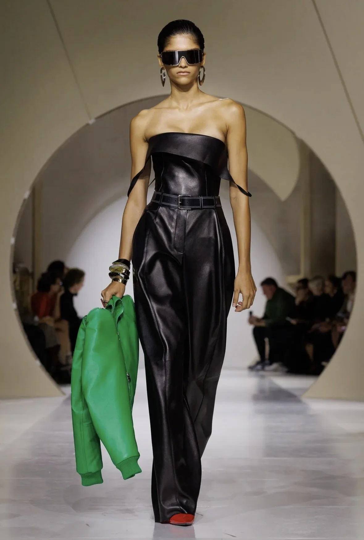 A strapless black jumpsuit and a vivid green accent.