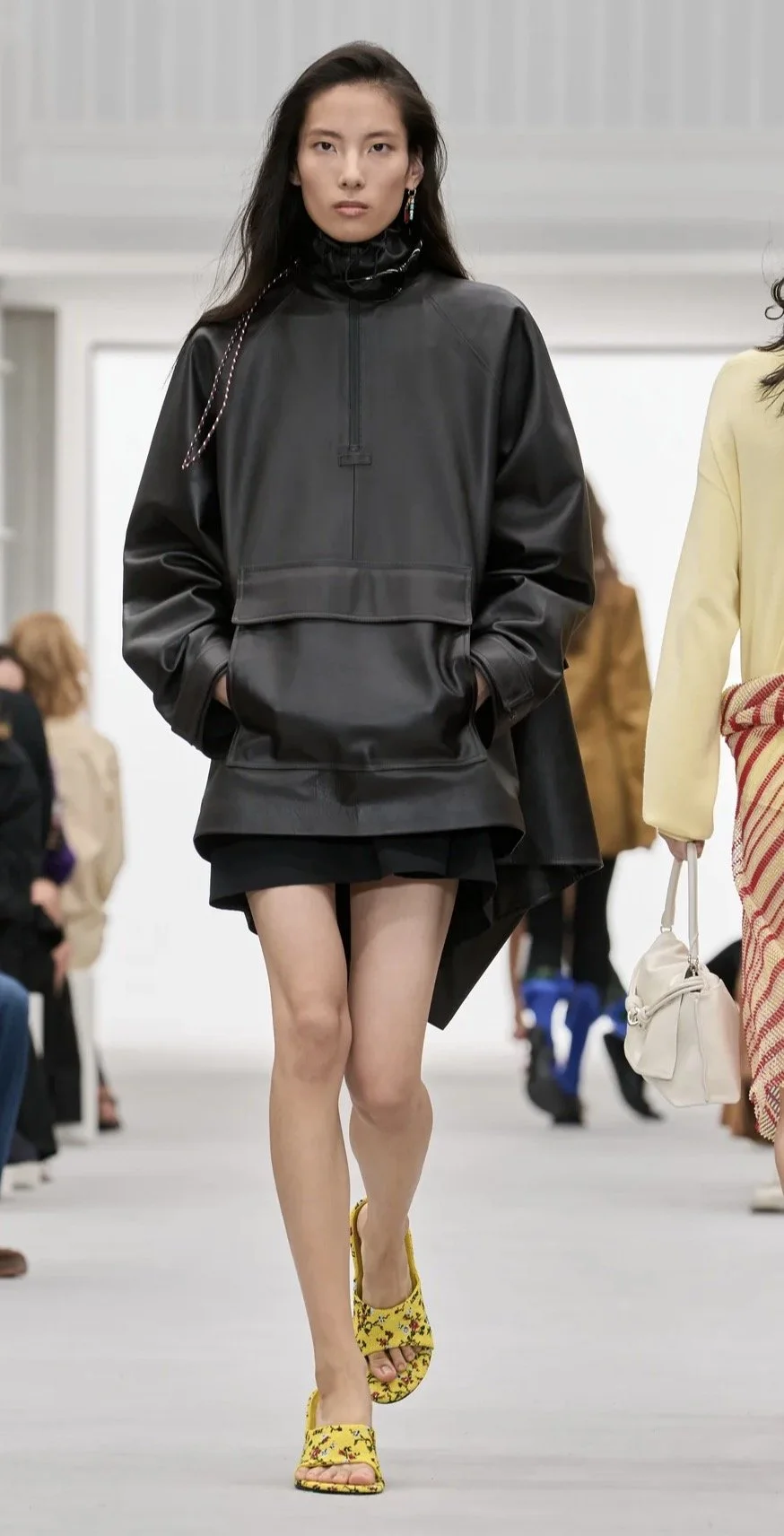 An oversized black anorak with yellow floral shoes.
