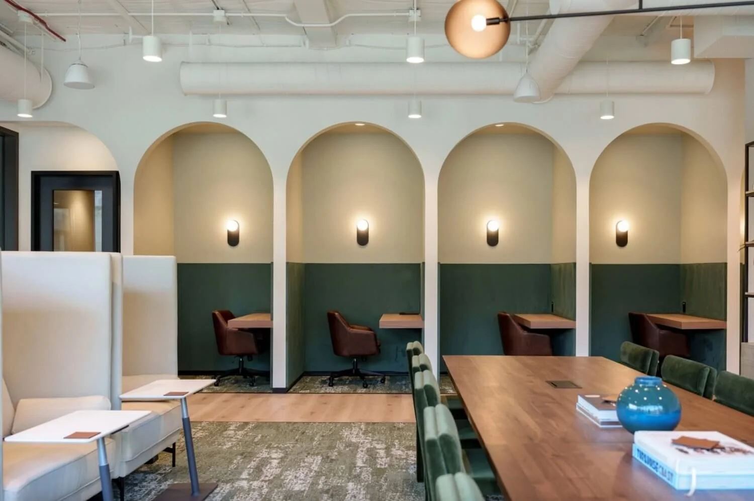 Industrious Malibu workplace lounge with arched study nooks and warm lighting
