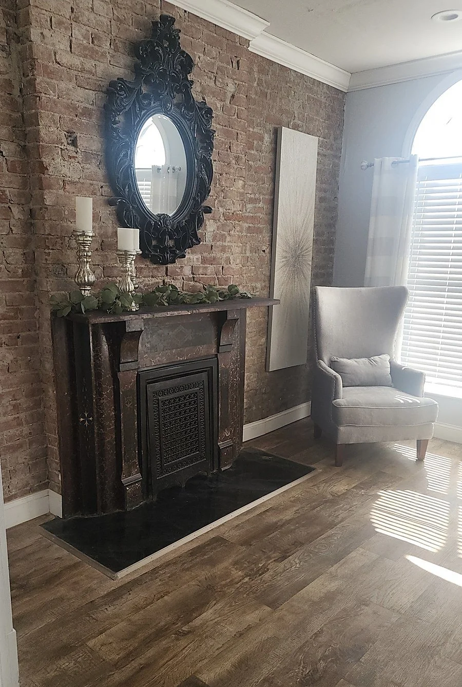 The master suite sitting area with an antique marble fireplace and ornate mirror