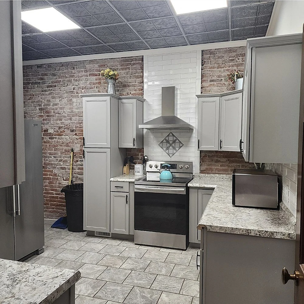 The full-scale updated kitchen at Your Boutique Hotel with exposed brick and stainless appliances