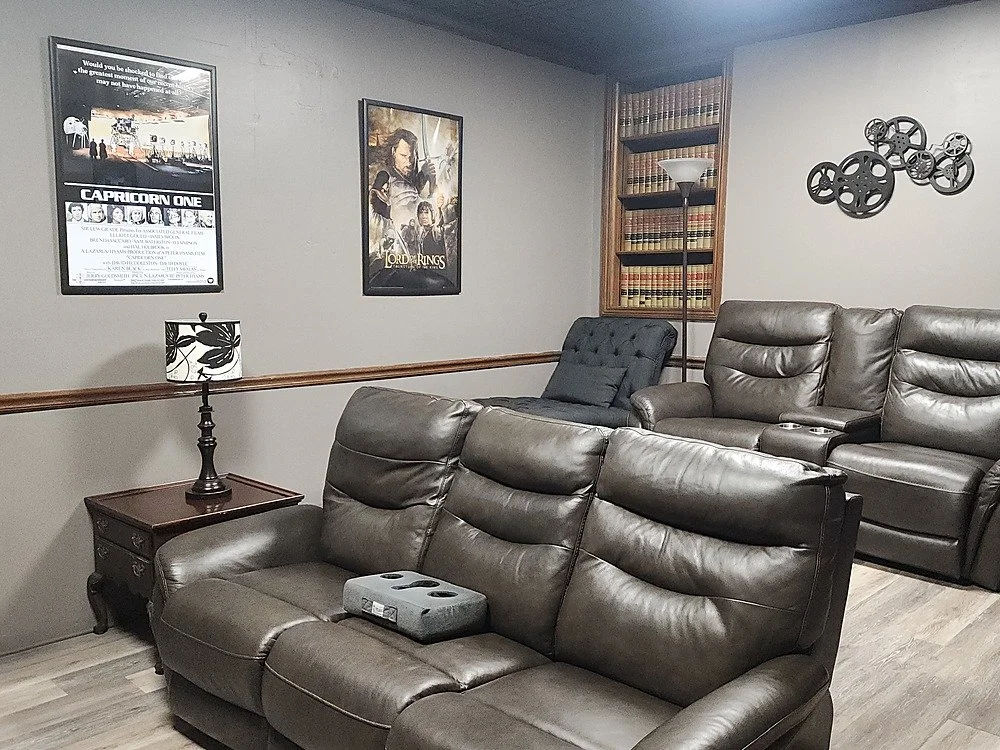 The home theatre room at Your Boutique Hotel showing the back of the room with leather reclining sofas
