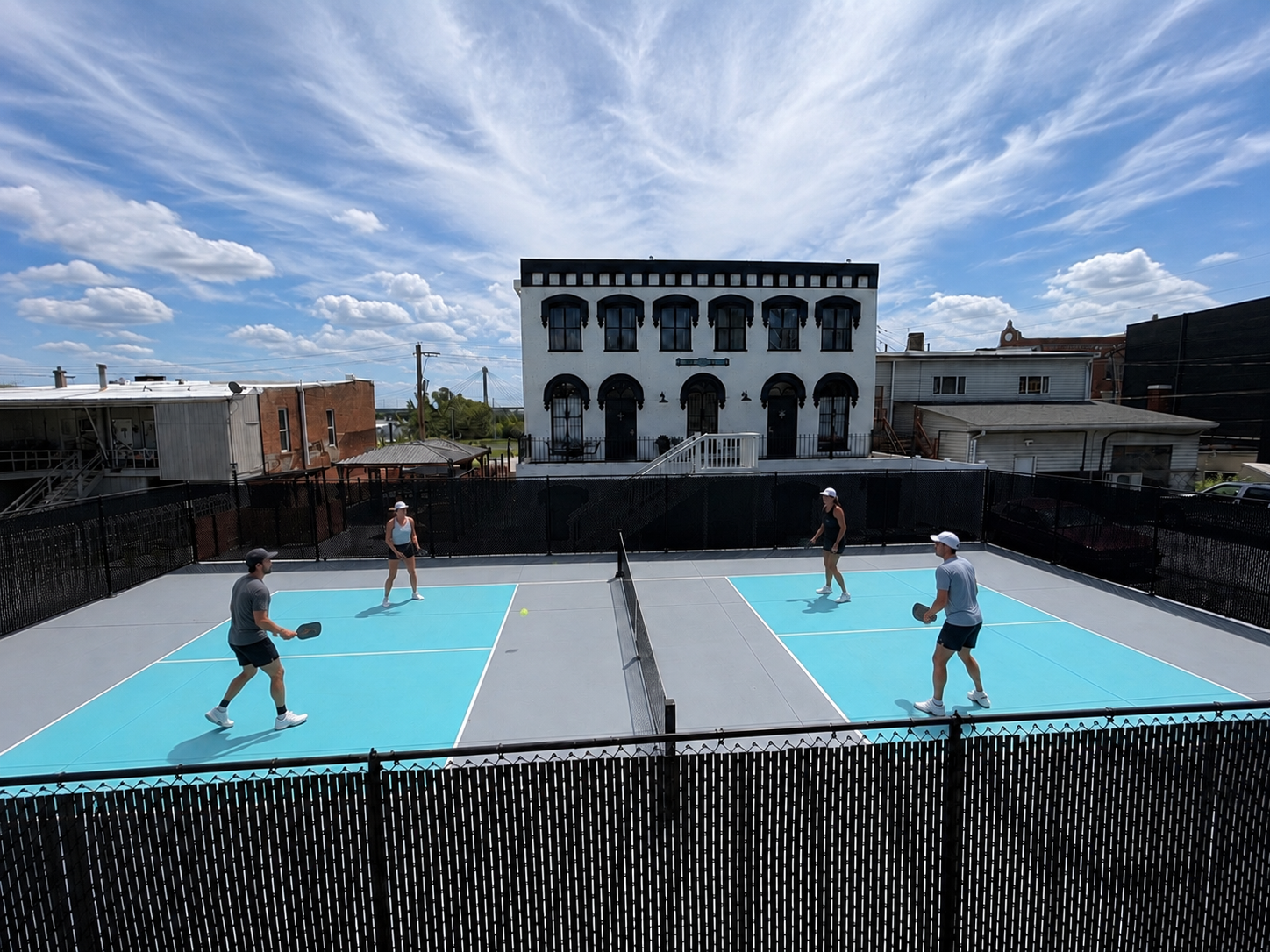 Guests playing doubles pickleball on the private court at Your Boutique Hotel in downtown Alton, IL