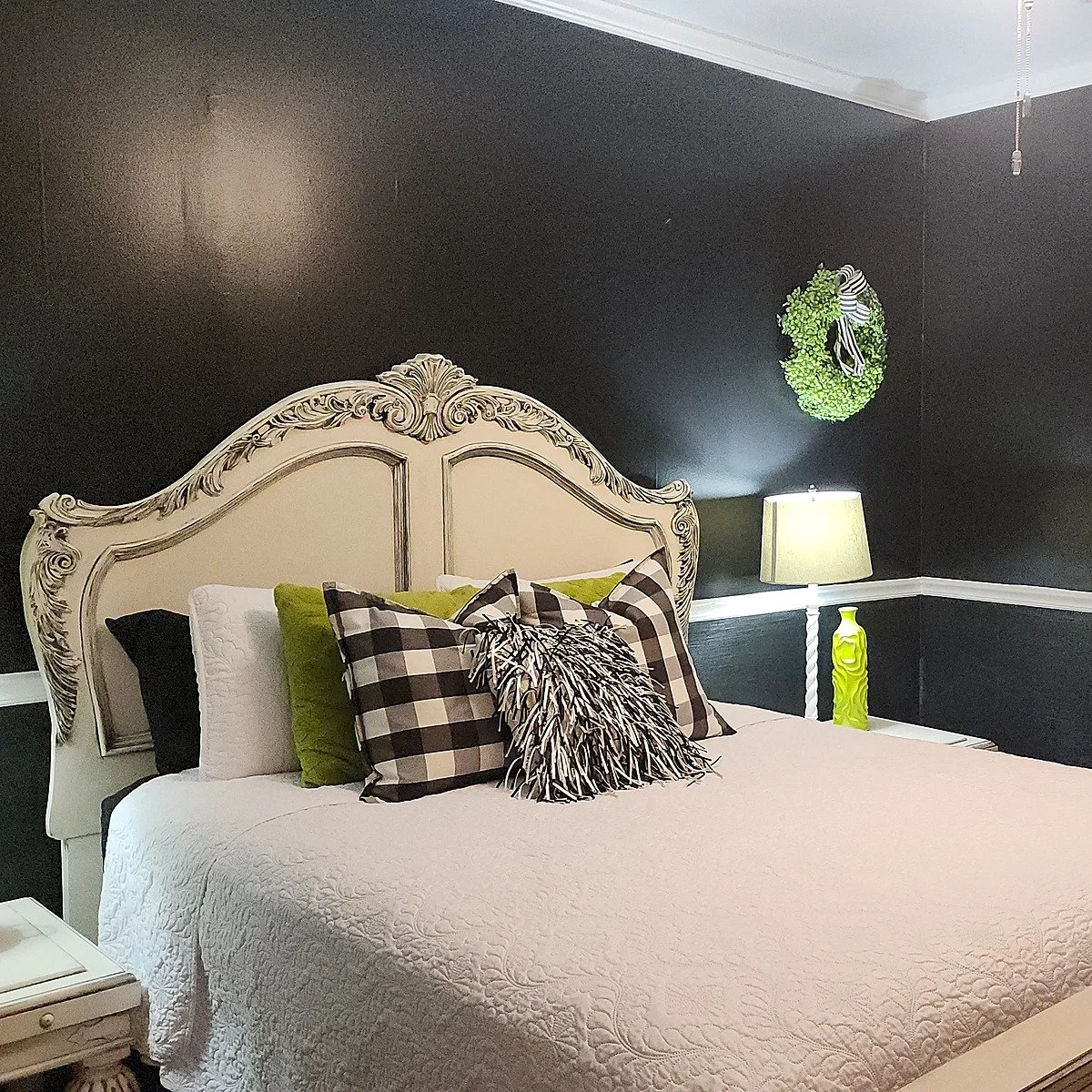 The Black and White Room, a guest suite with dark walls and plaid accent pillows