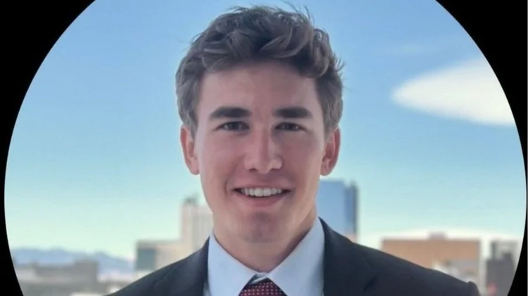Photo of man with a city skyline in the background.