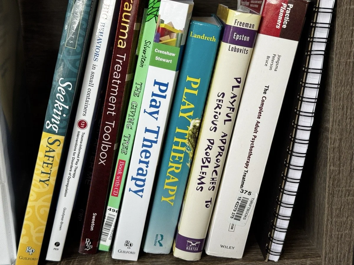 Bookshelf of play therapy and child-focused clinical texts at Brain & Heart Healing, Abilene TX