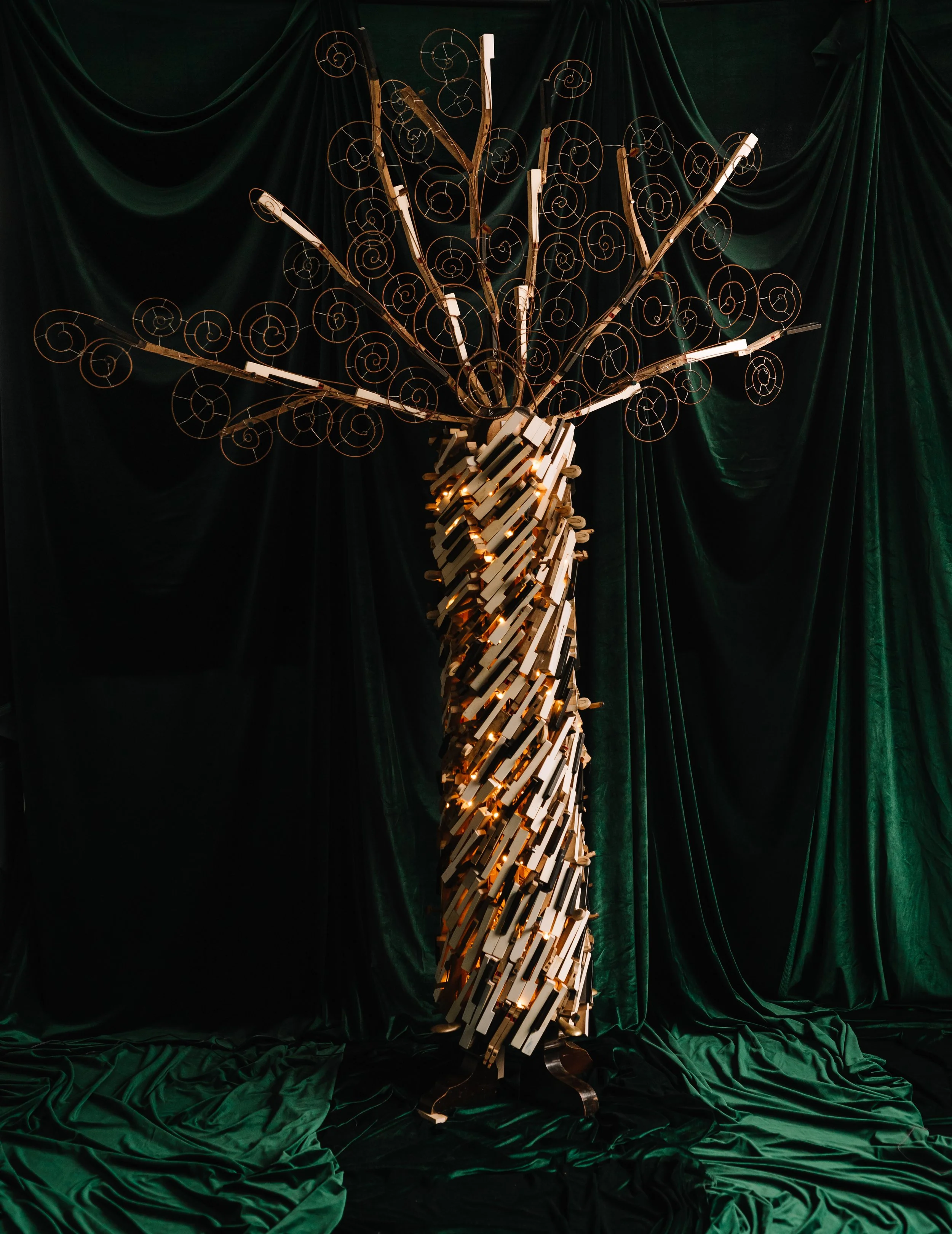 The fairy tree Dara built from second-hand pianos, lit with fairy lights