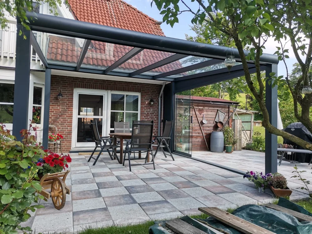 Terrassenüberdachung mit Glasdach über einer Gartenterrasse