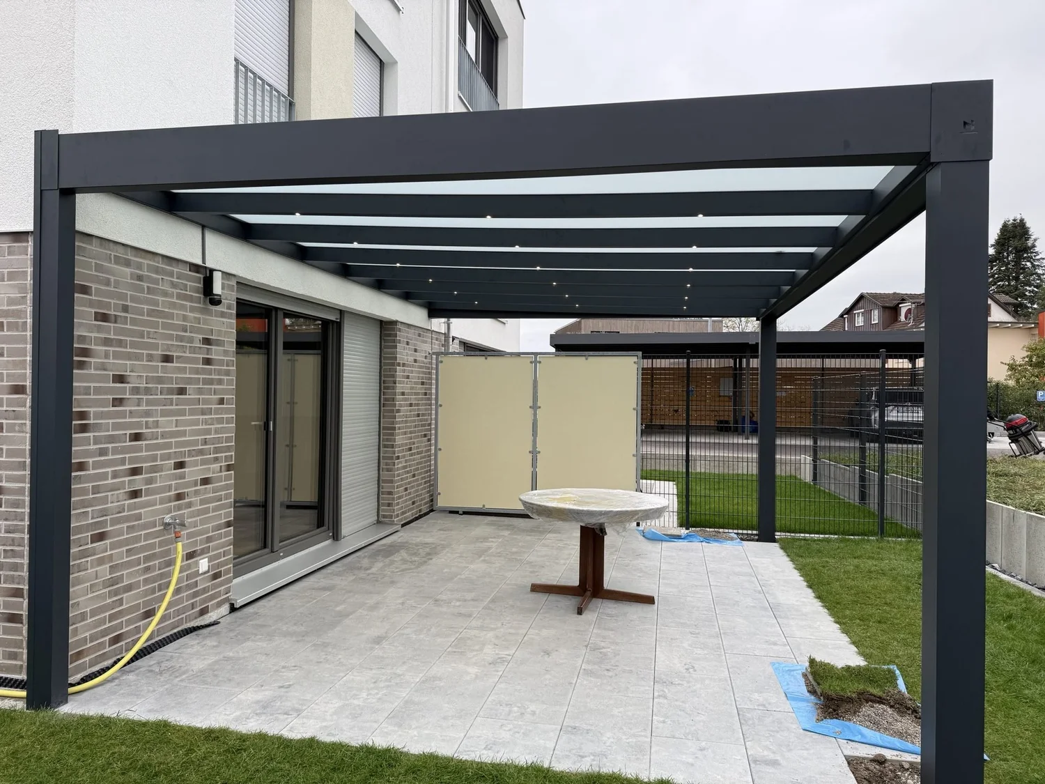 Kubische Terrassenüberdachung in Anthrazit mit Mattglas und LED-Spots an einem Neubau in Salem