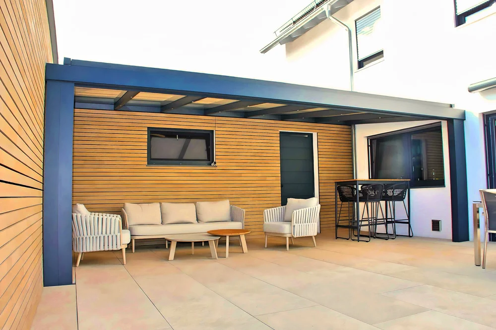 Terrassenüberdachung mit Lounge vor Holzfassade