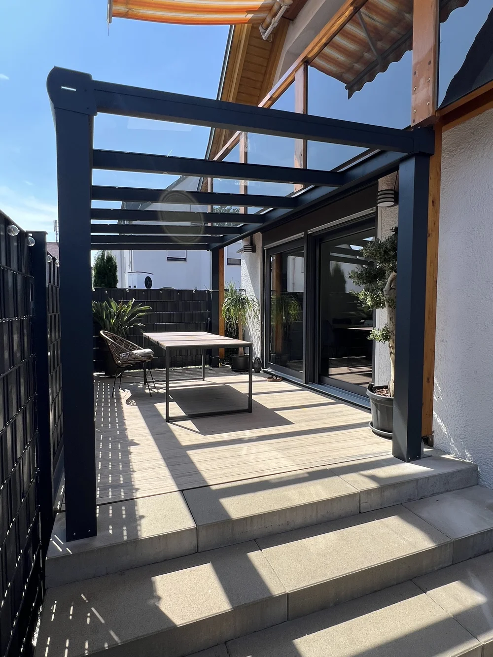 Terrassendach mit Glas an einem Haus mit Holzfassade von Kastonia