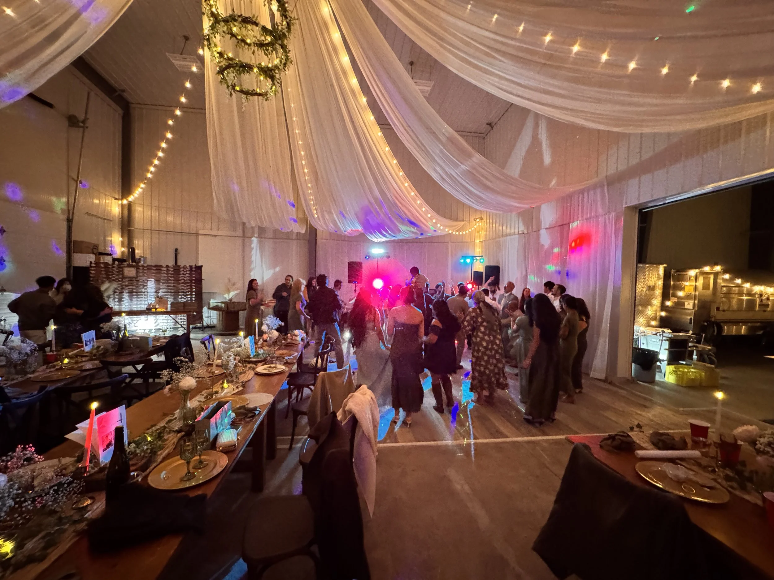 Wedding guests dancing beneath the draped winery ceiling