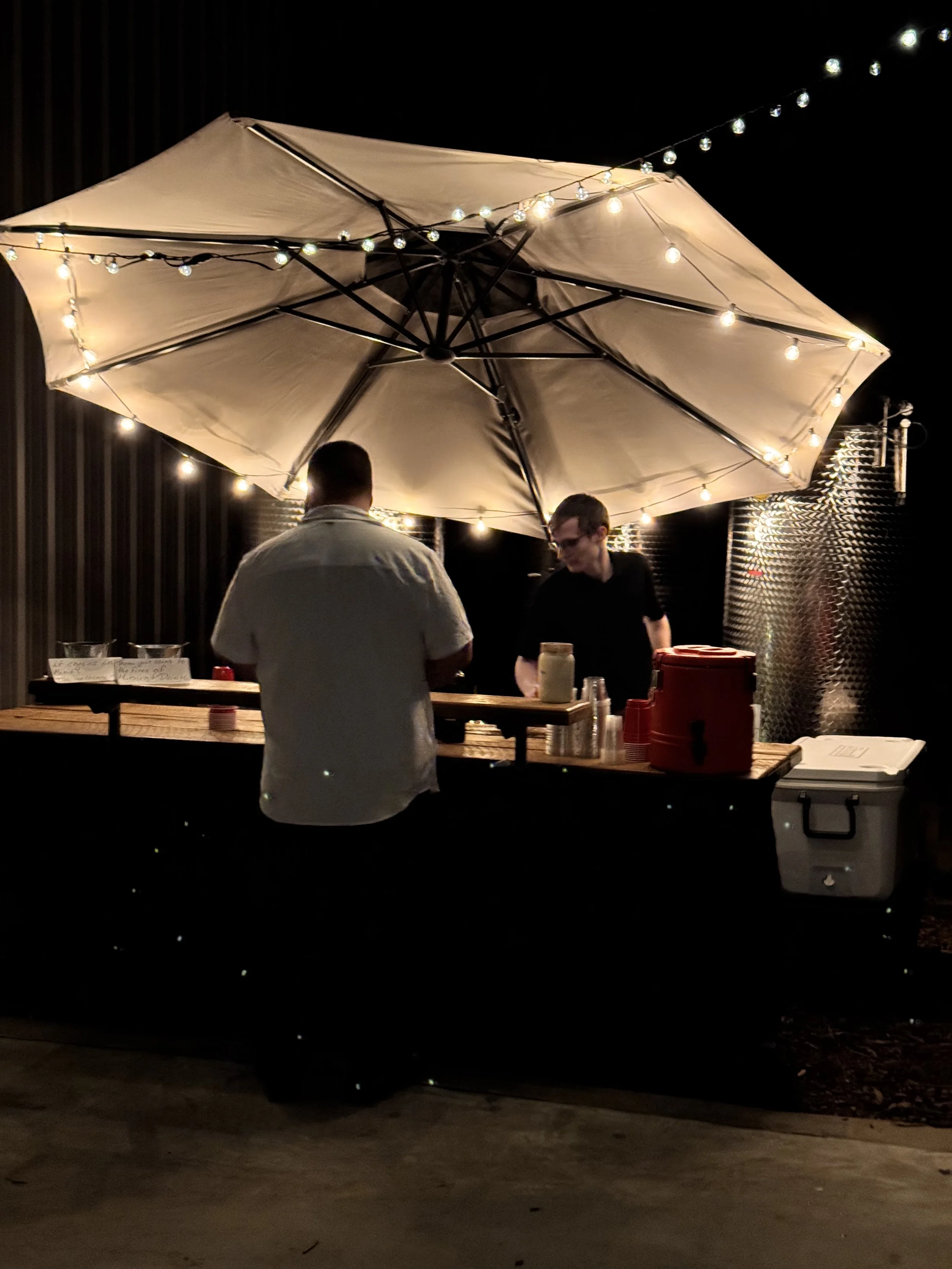 Outdoor wedding bar under string lights at night