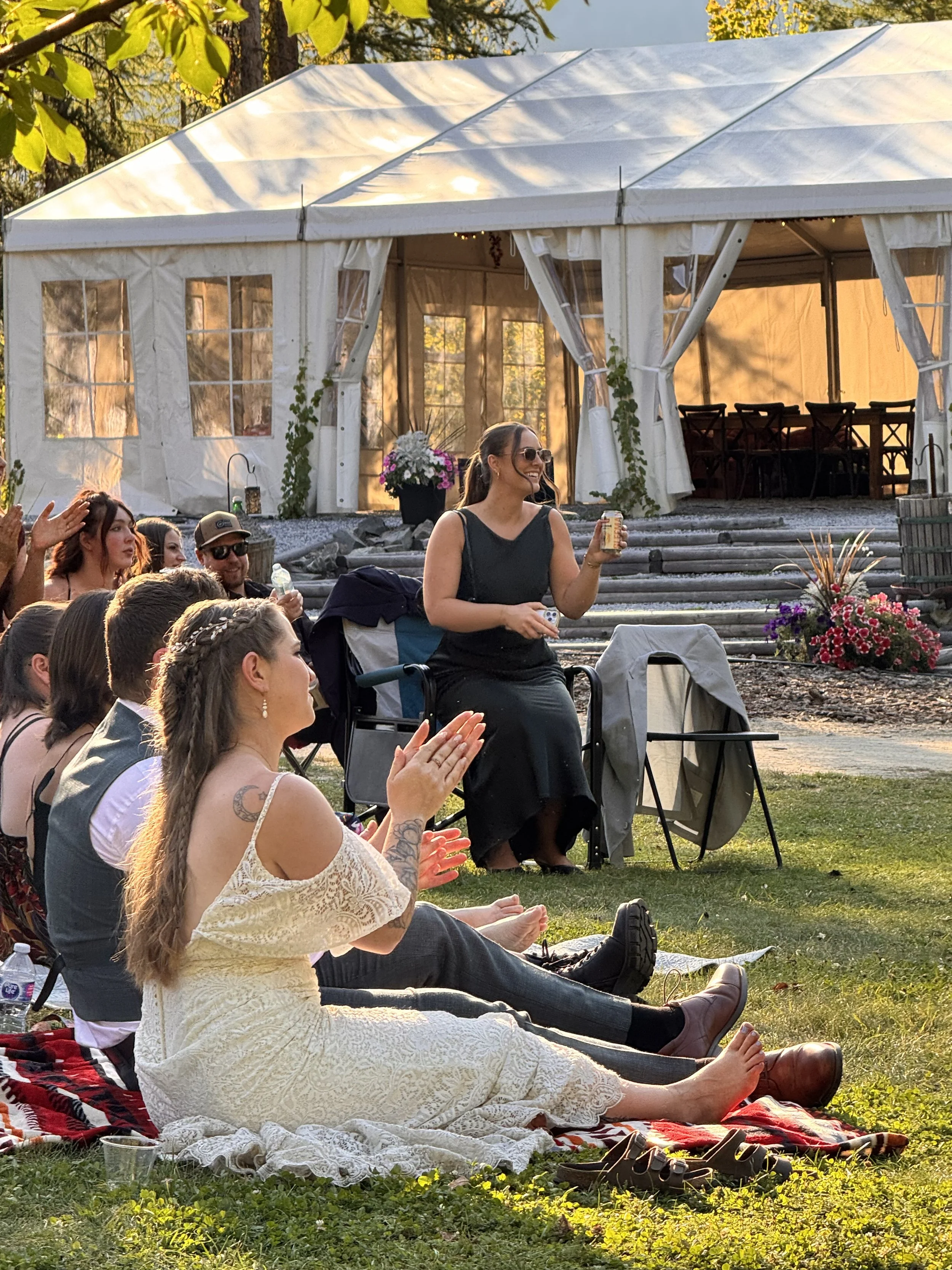 Wedding guests relaxing outdoors beside the Mountain Soul event tent