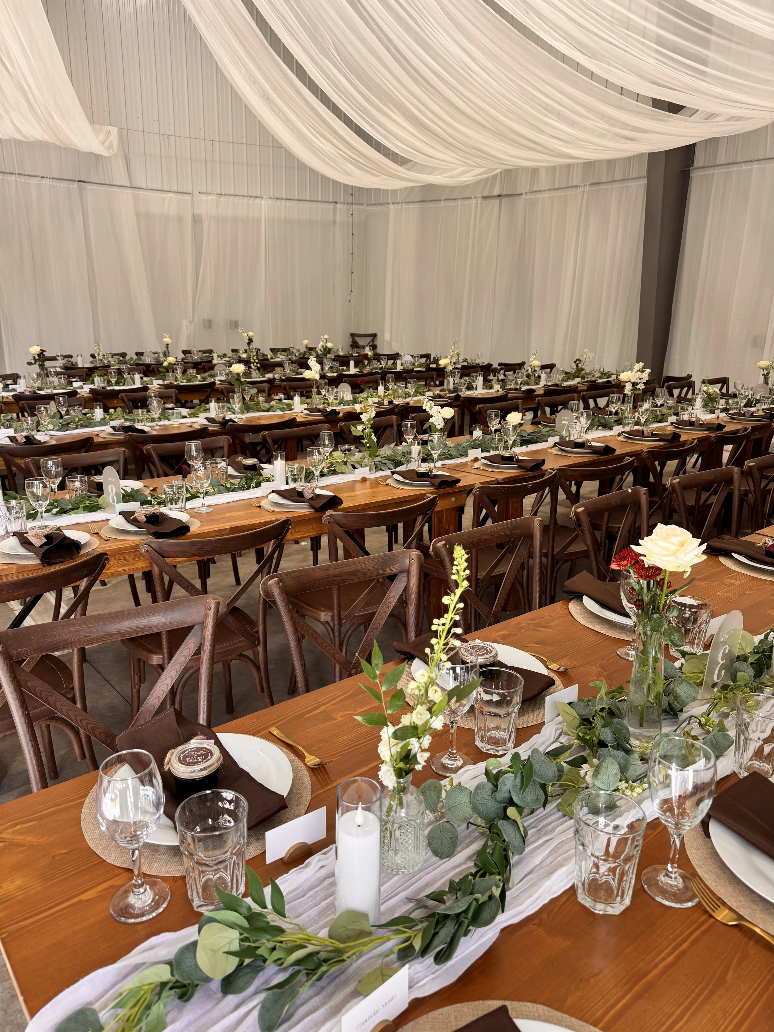 Farm tables and cross-back chairs set for a Mountain Soul wedding reception