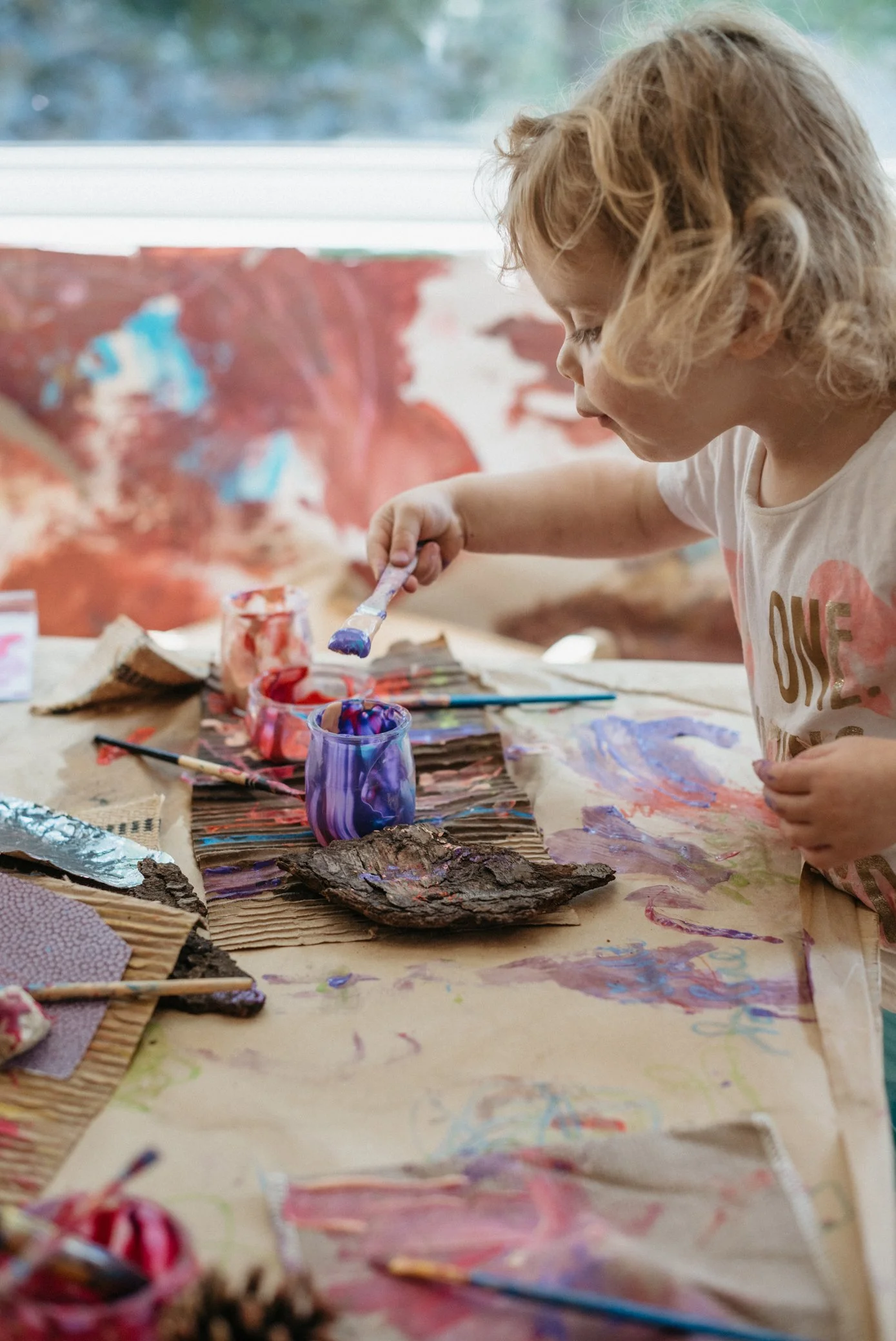 A child exploring paint and creative materials at Atelier Kids.