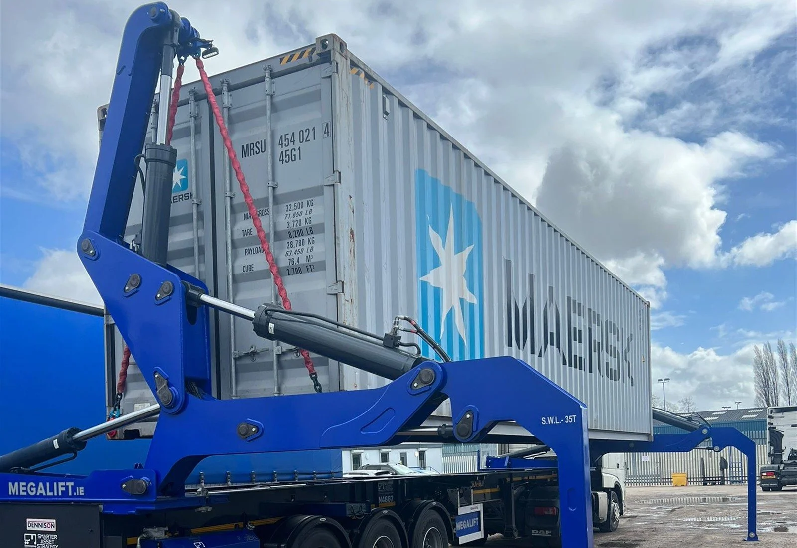 Container side-loader trailer using hydraulic lifting arms and stabilisers to handle a shipping container.