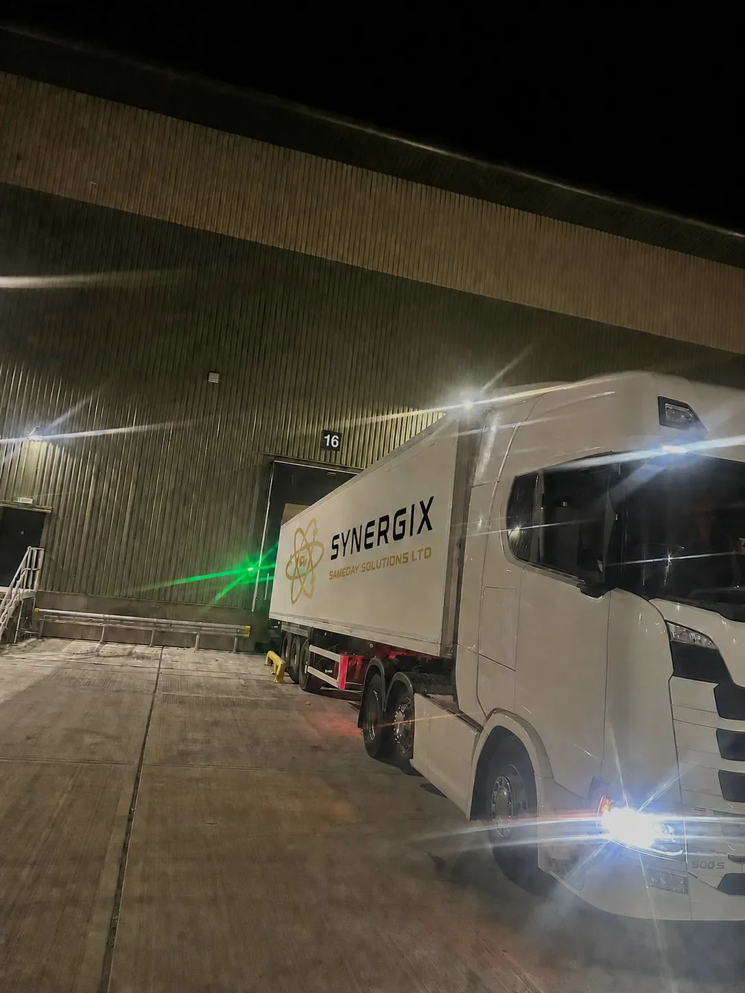 Genuine Synergix articulated lorry working at a loading bay at night