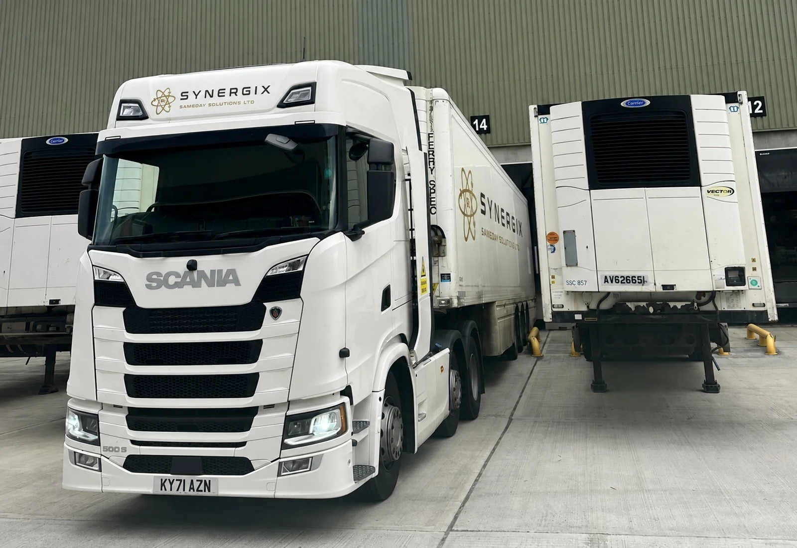 White Synergix-branded Scania articulated truck at warehouse loading bays.