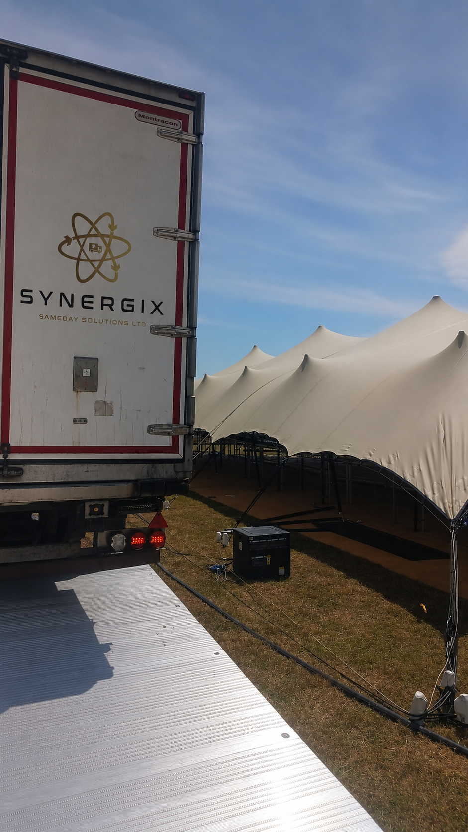 Synergix refrigerated trailer beside an event marquee
