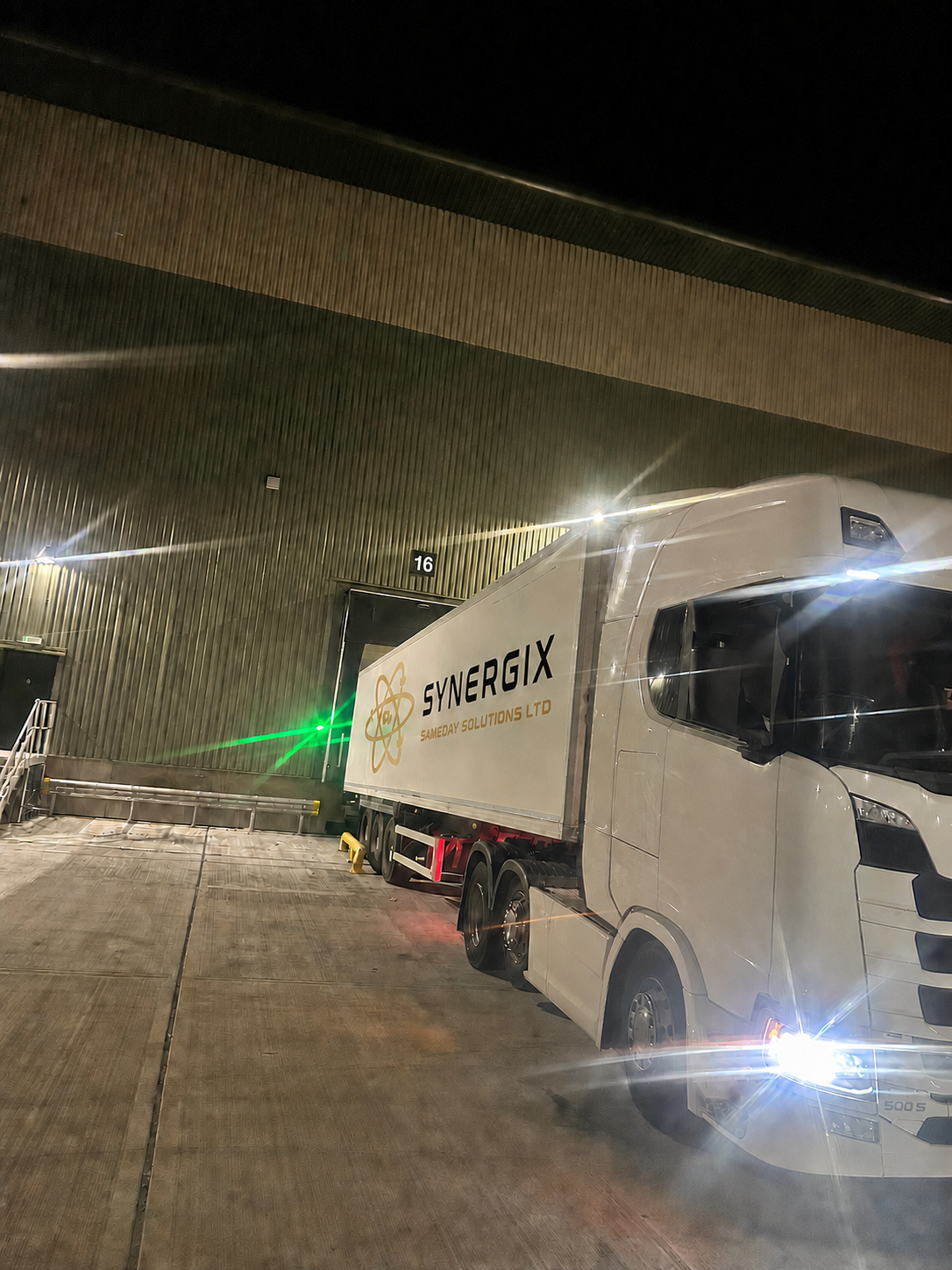 Genuine Synergix articulated lorry working at a loading bay at night