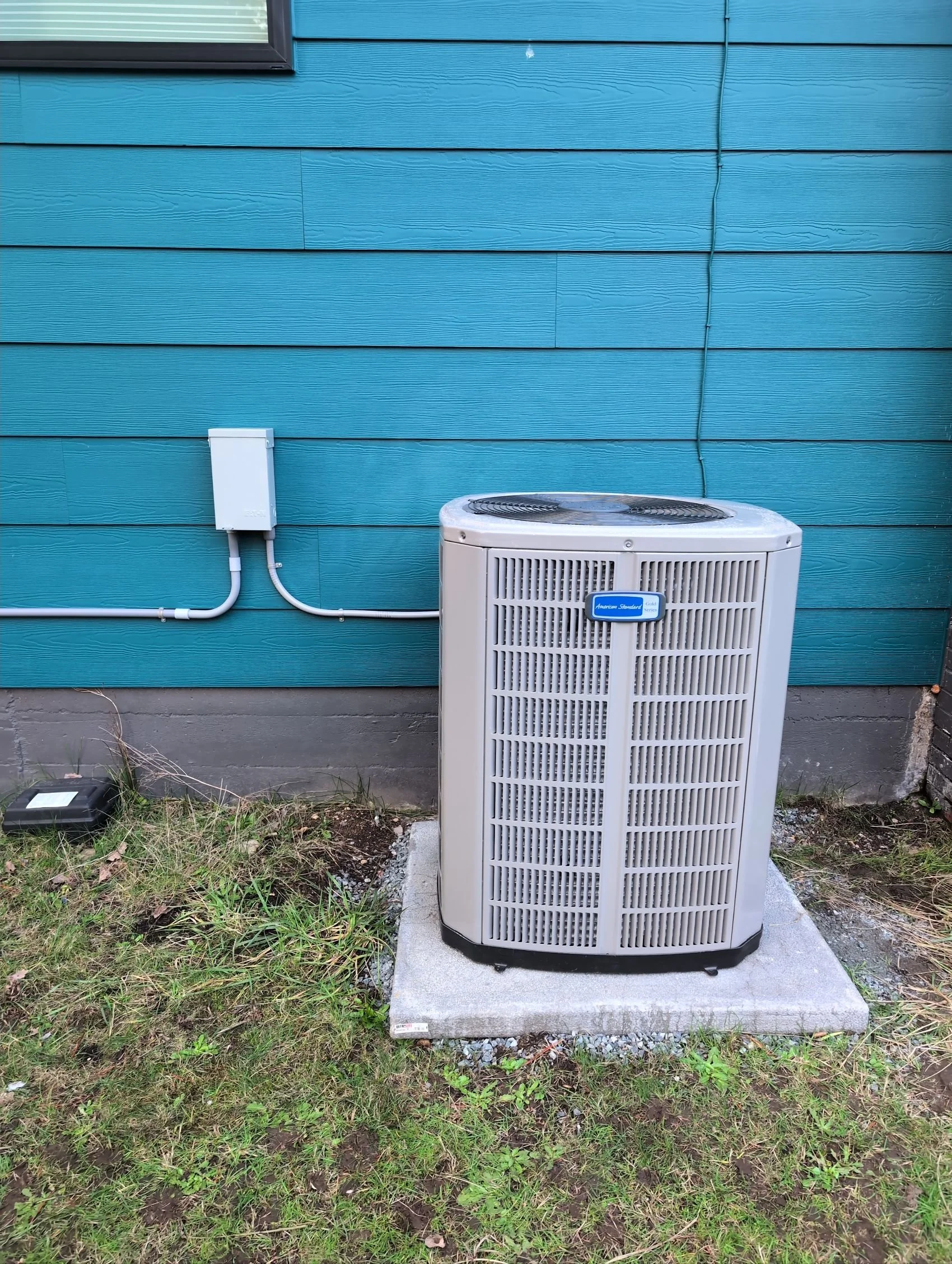 Front view of outdoor unit with wall-mounted disconnect